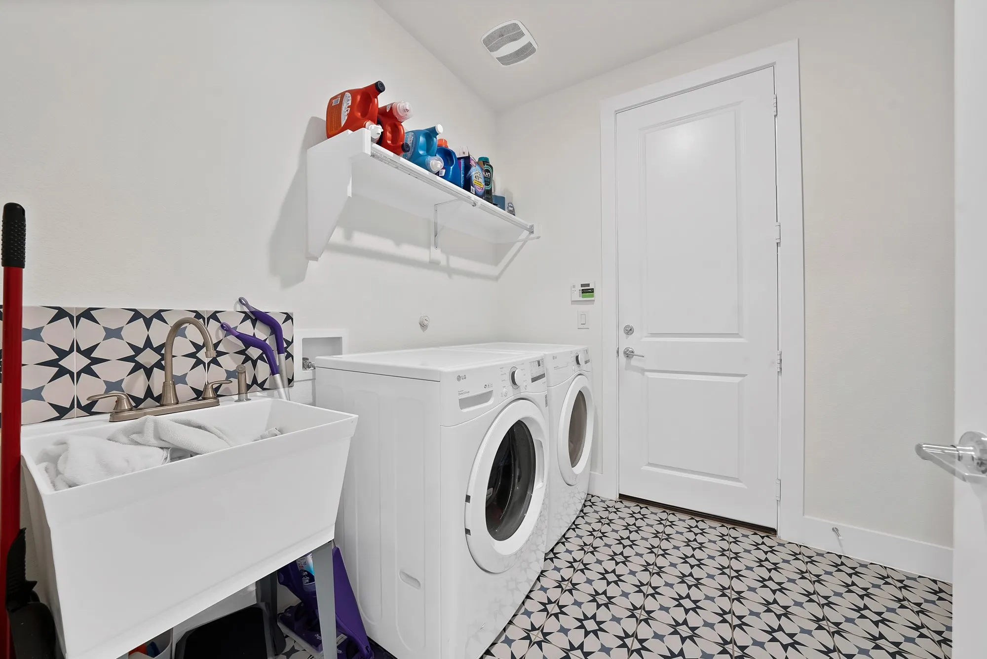 Spacious laundry room boasts a sink and additional space.
