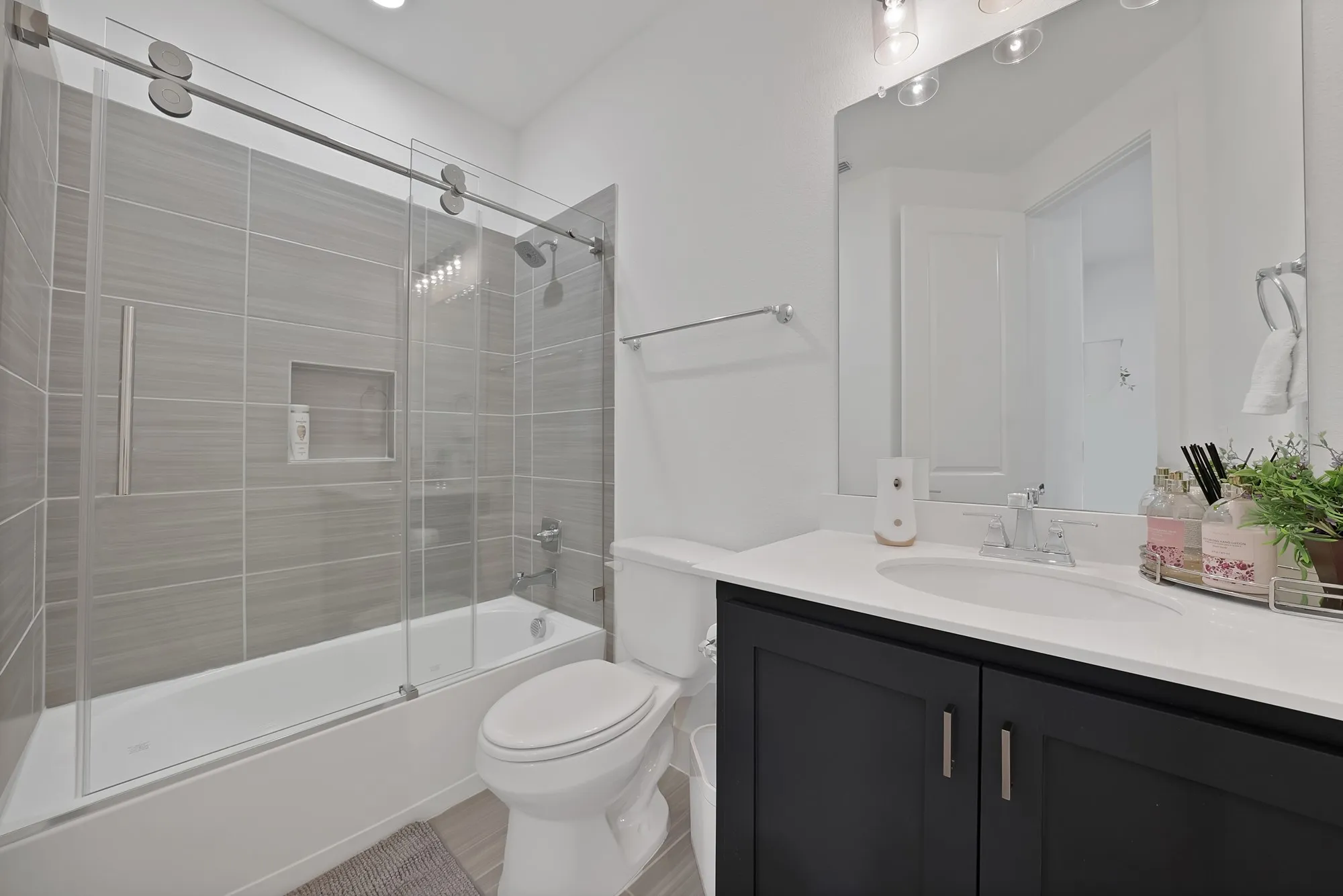 Full bathroom downstairs with barn door style glass doors.