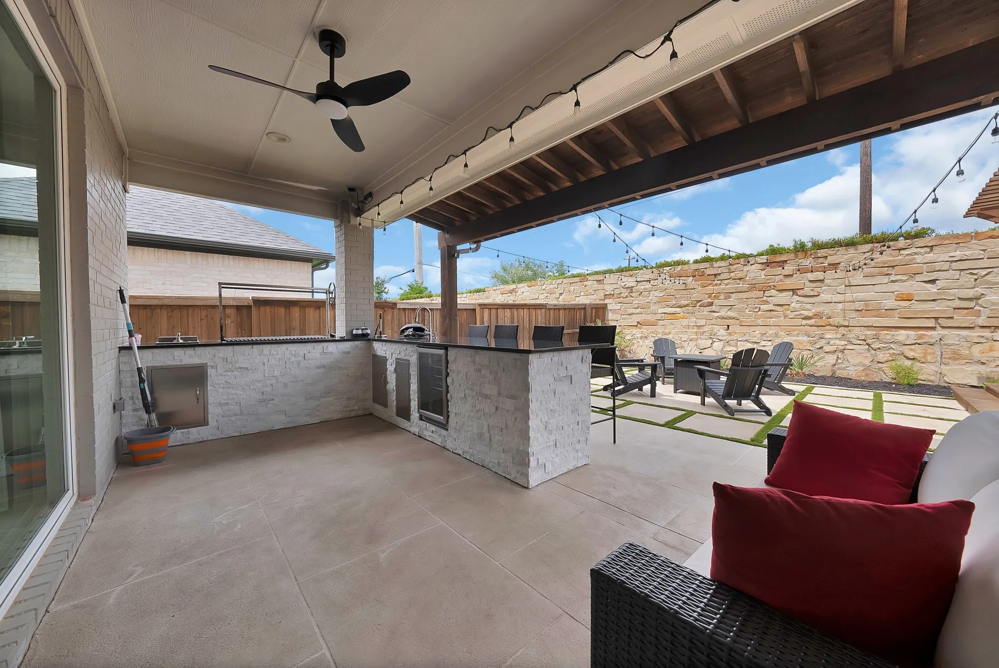 Wonderful outdoor kitchen is equipped with a built-in charcoal grill, gas burner, sink, beverage refrigerator and storage.