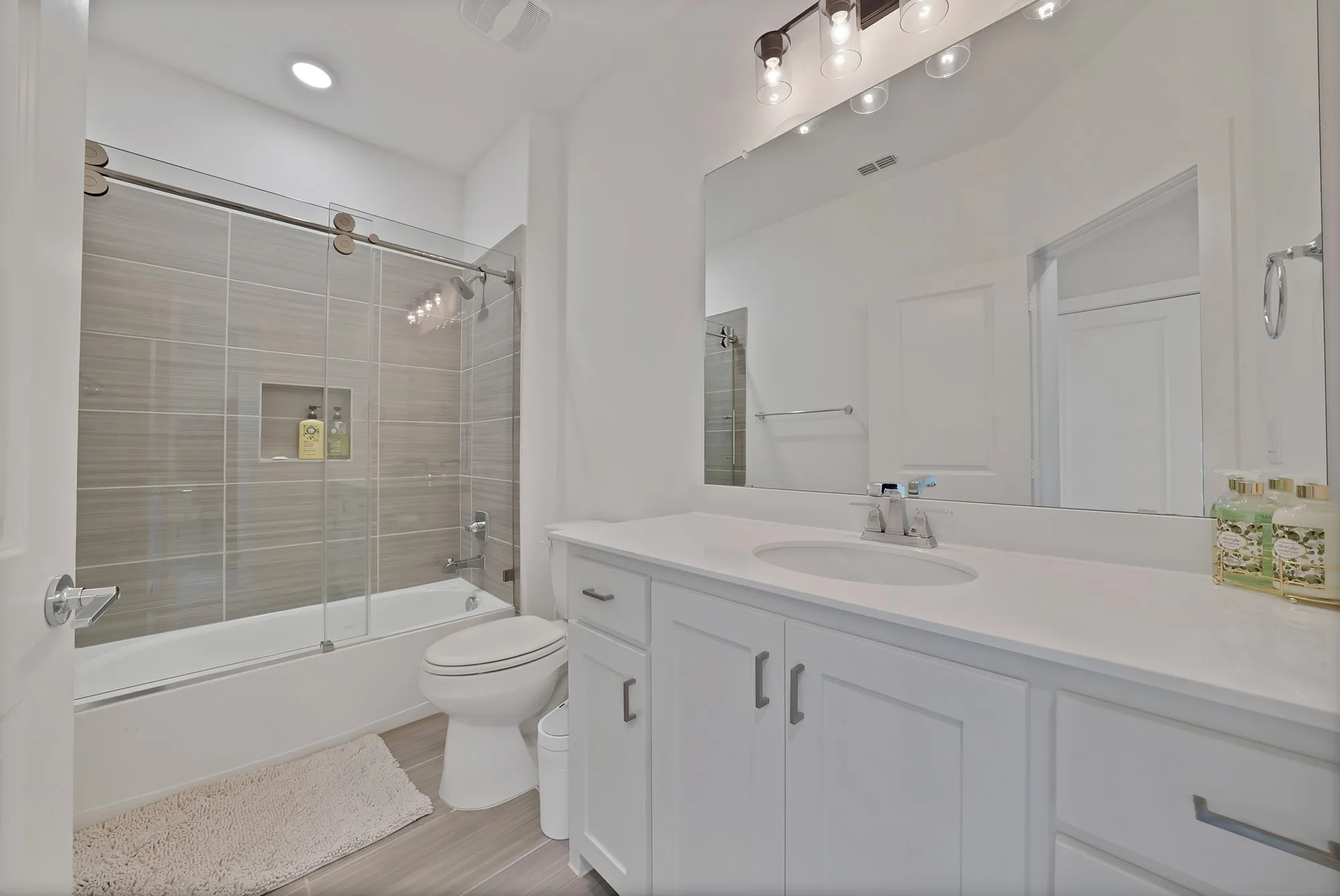 Full bathroom upstairs with barn door style glass doors.
