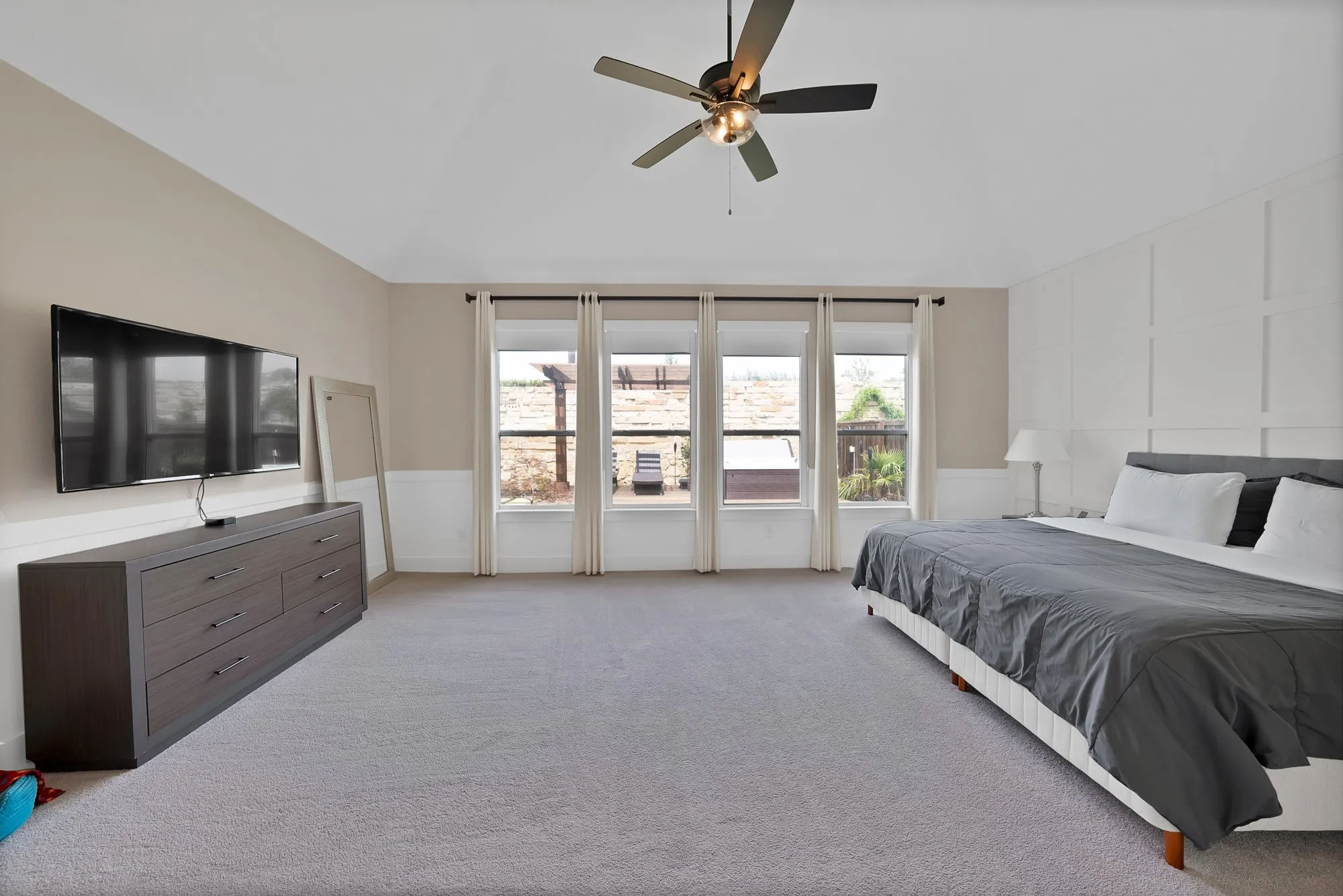 Luxurious primary suite overlooks the wonderful backyard.
