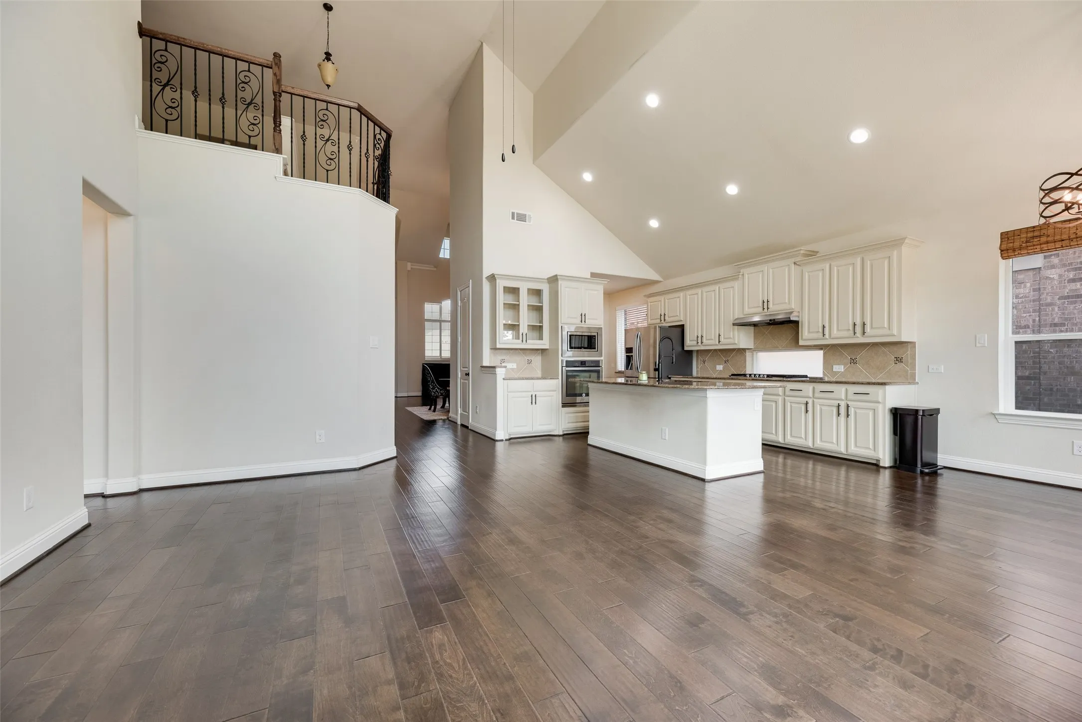 Huge family room space with chef's kitchen with gas cooktop, butler's pantry and breakfast nook in the background.