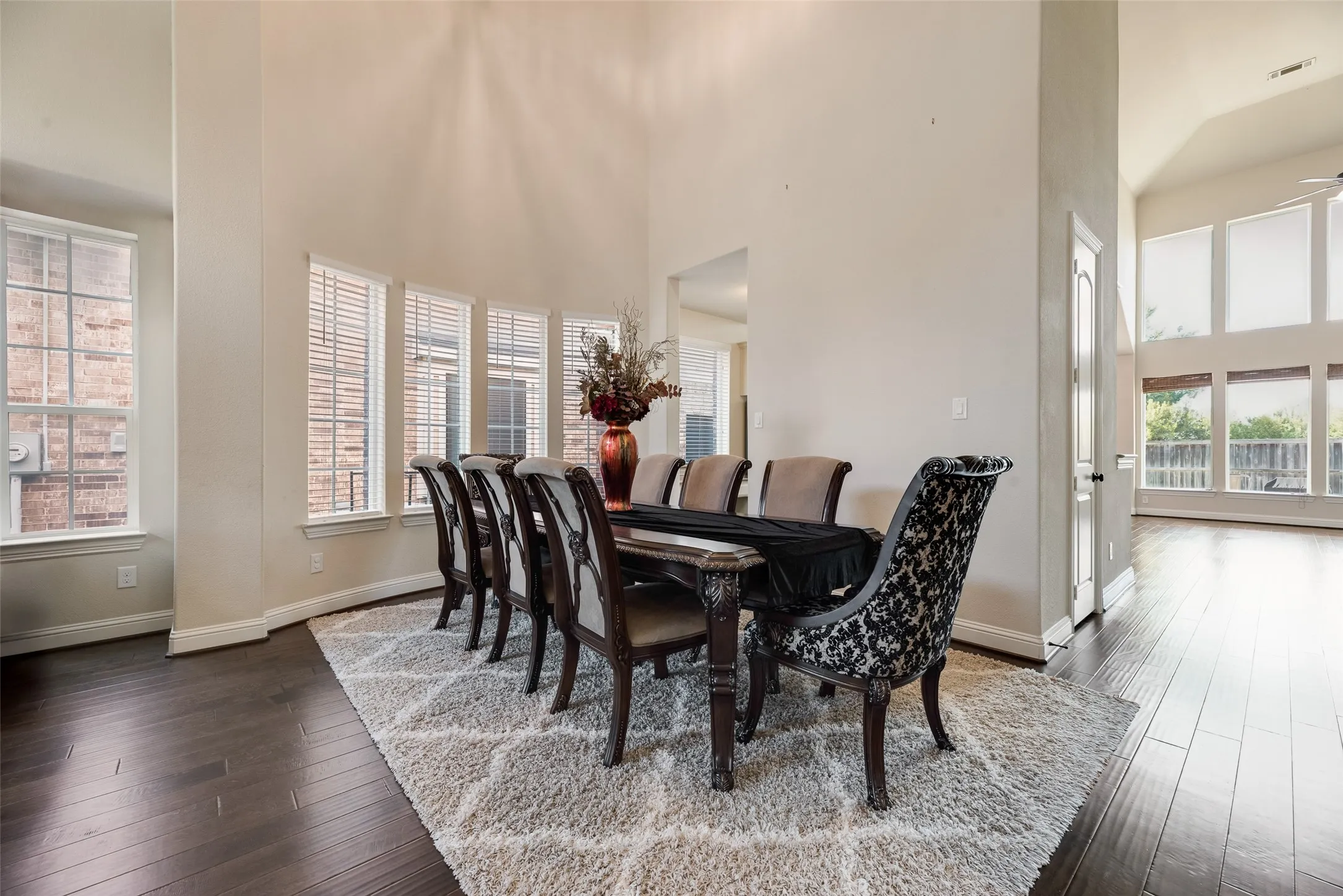 Formal Dining Room with view of open family room with exceptional views of natural light coming in through the floor to ceiling windows.