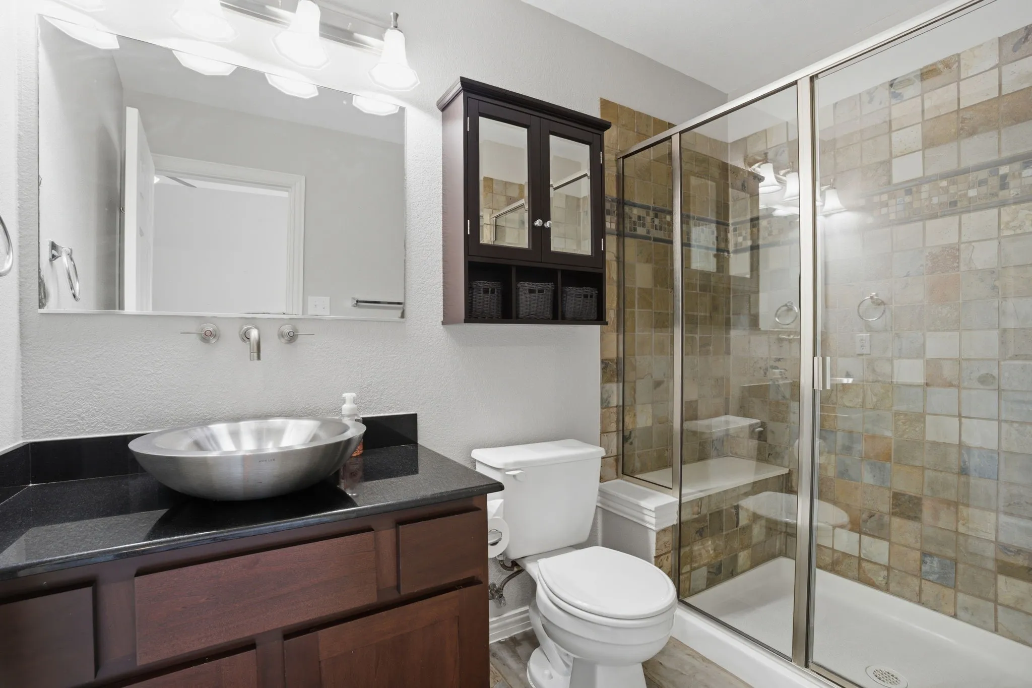 Bathroom featuring a walk-in shower with tiled walls and a built-in bench