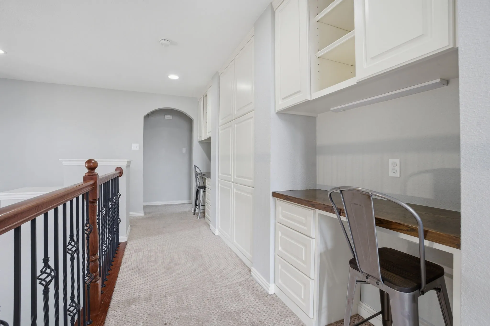Custom built-in desk area featuring white cabinetry, a wood-finish countertop, and recessed lighting
