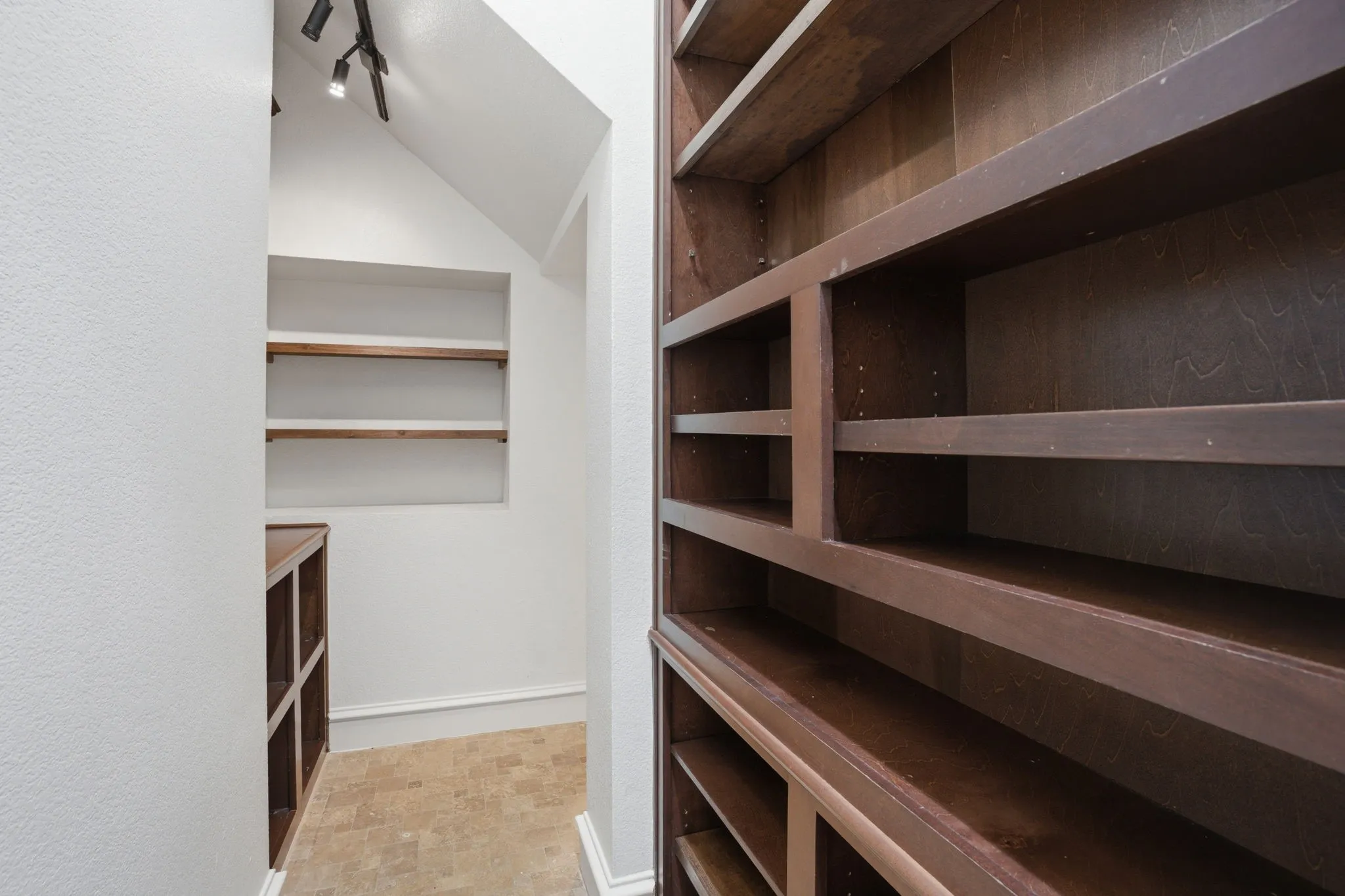 Massive under the stair pantry. Featuring custom built-in shelving with dark wood-finish construction provides extensive storage