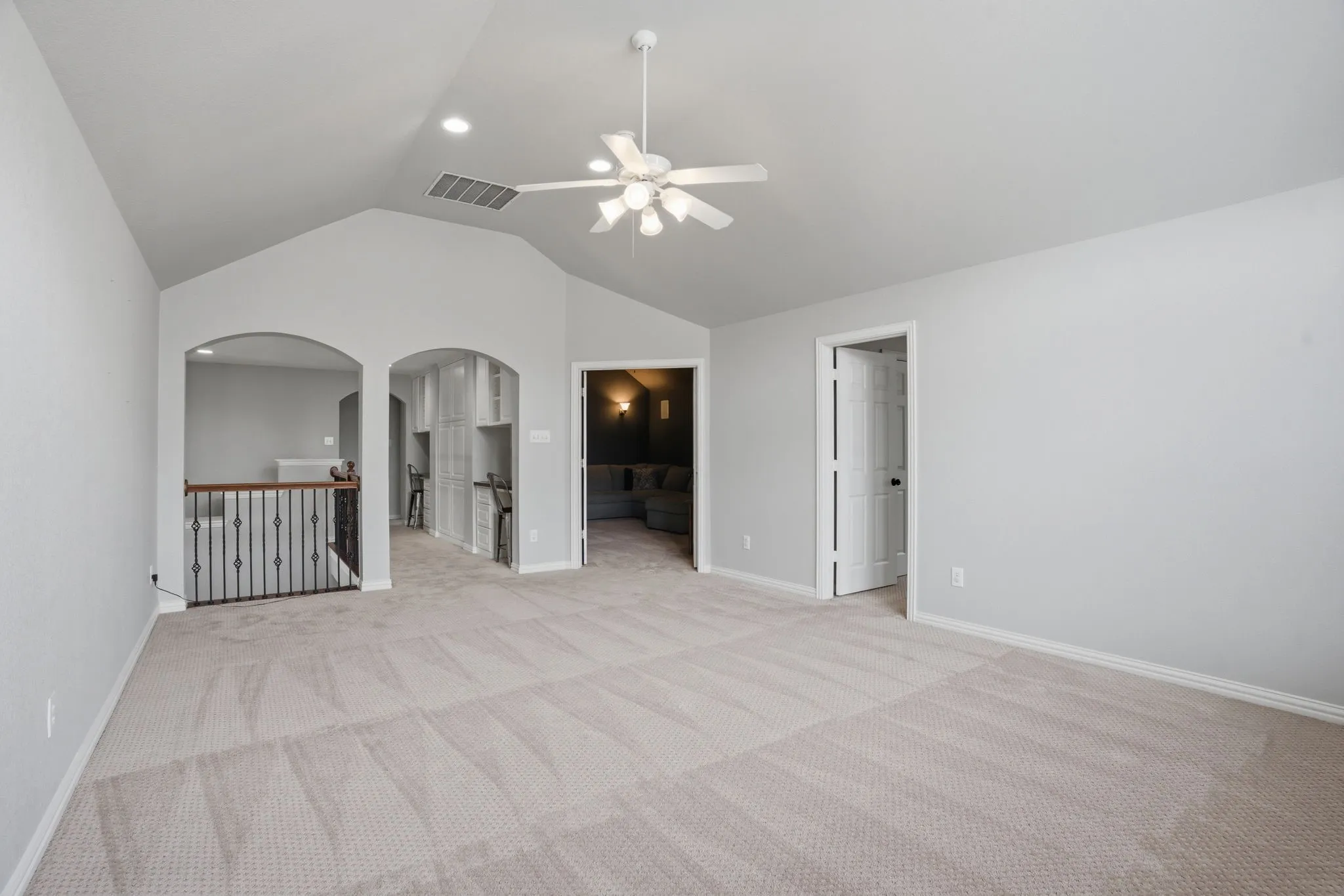 Carpeted loft area featuring a vaulted ceiling with a ceiling fan and recessed lighting