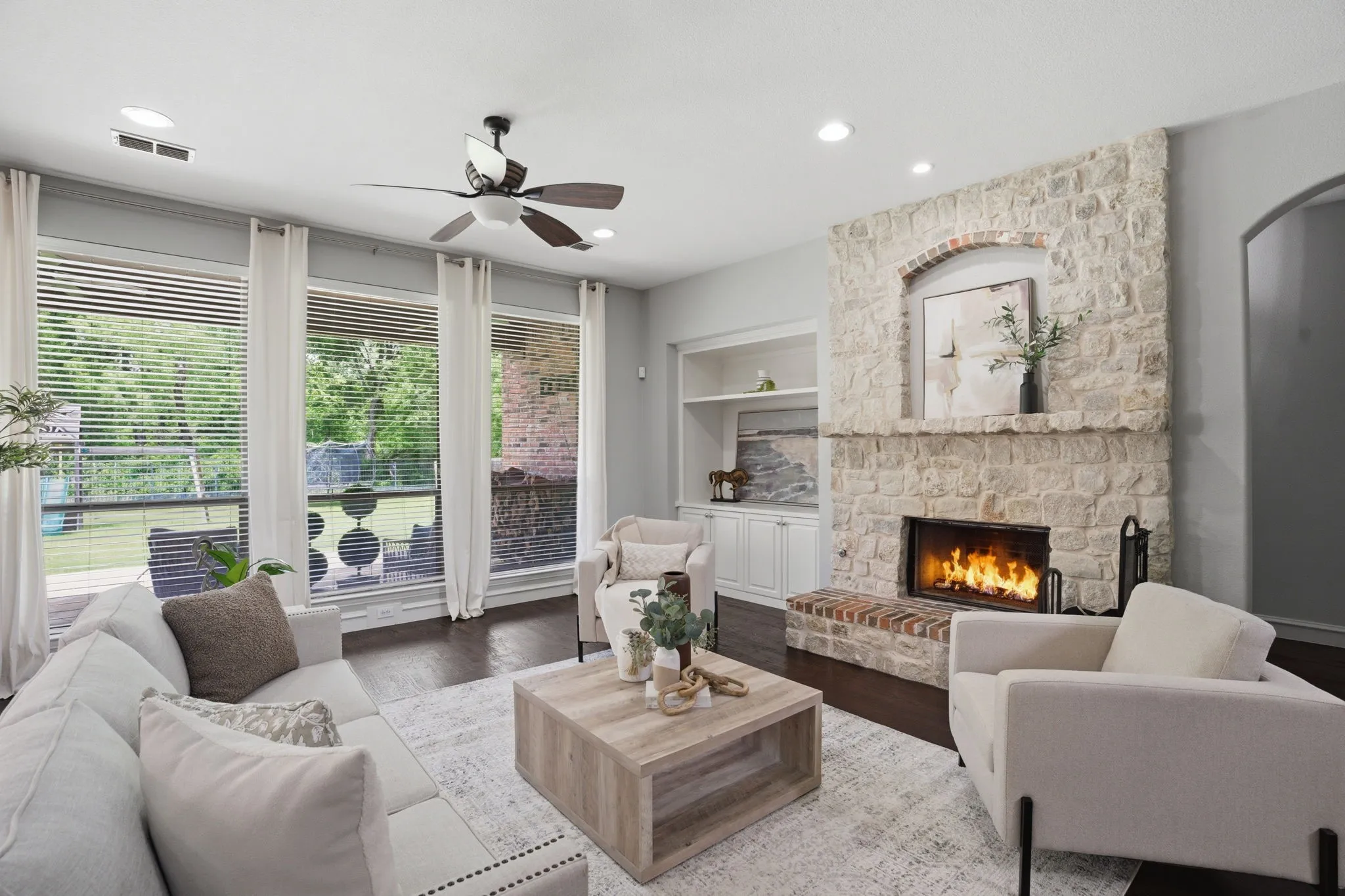 Living area featuring a stone-clad fireplace with an arched detail and brick hearth