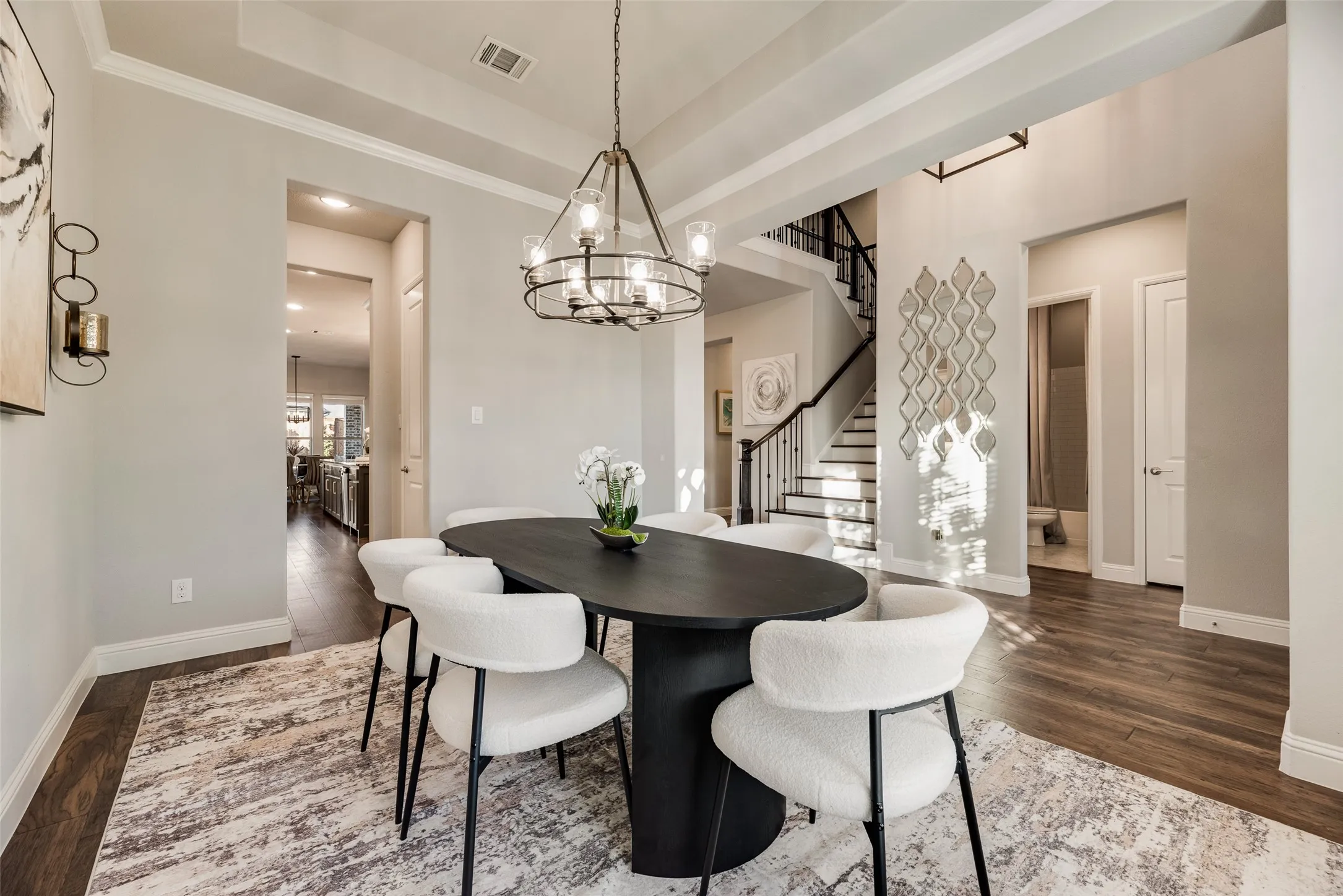 Dining area featuring a contemporary chandelier, tray ceiling, and wood-finish flooring