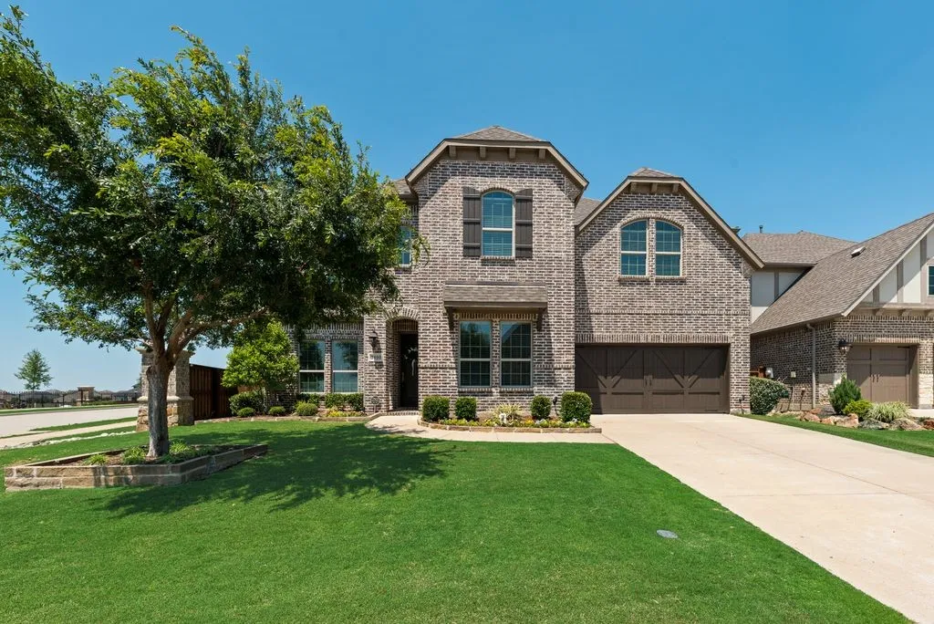 Brick exterior featuring multiple gables, an arched entry, and dark wood shutters