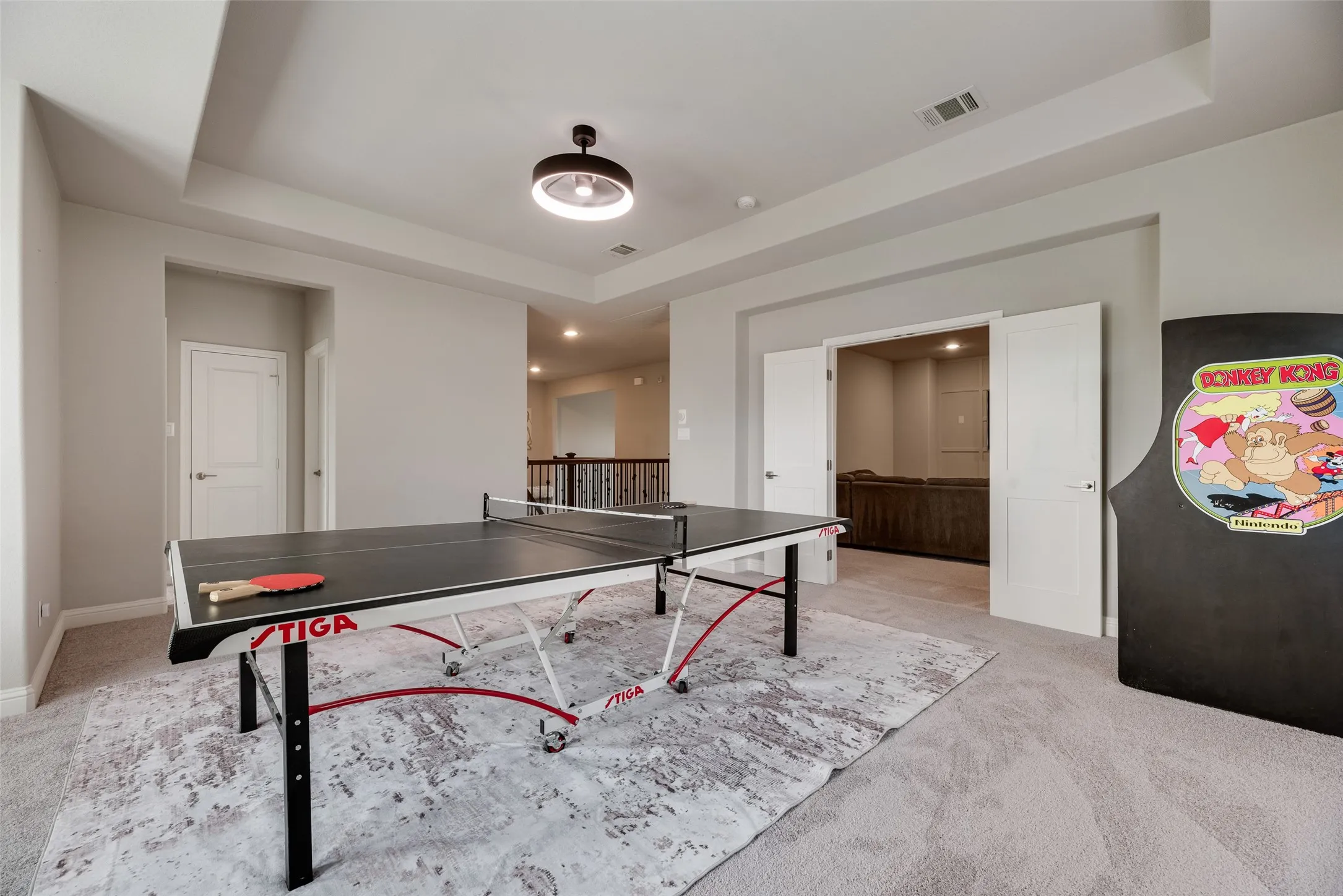 Spacious bonus room featuring light gray carpeting, tray ceiling, and recessed lighting