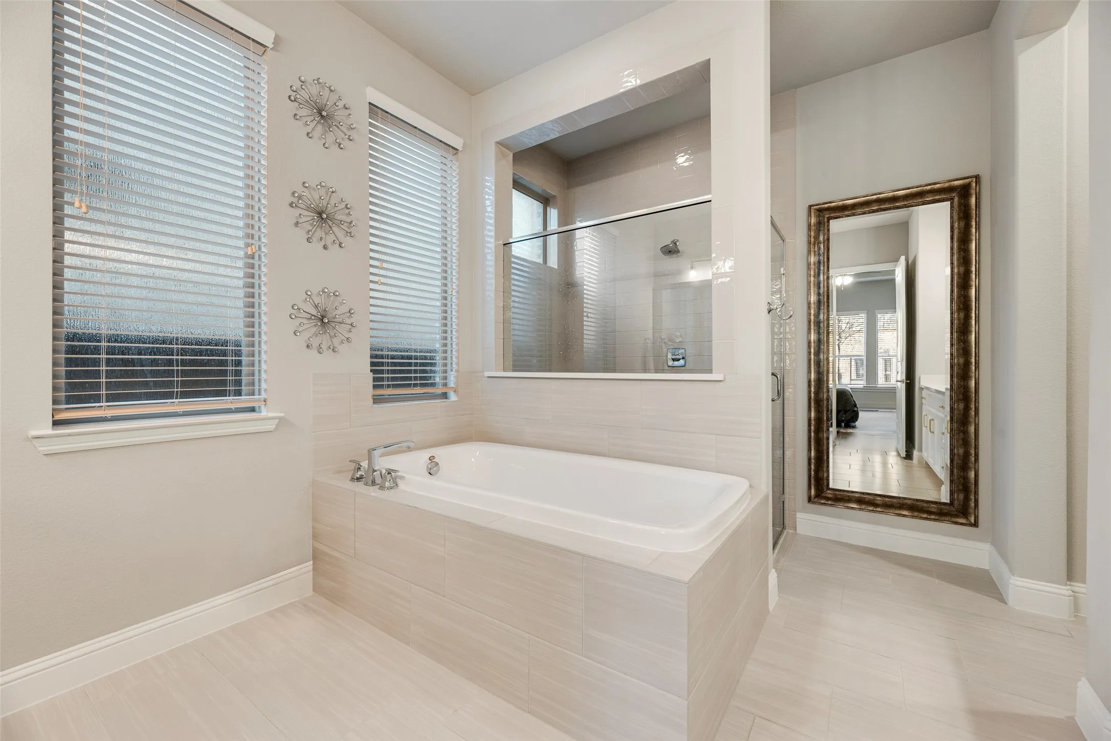 Soaking tub with chrome fixtures and light-toned tile surround