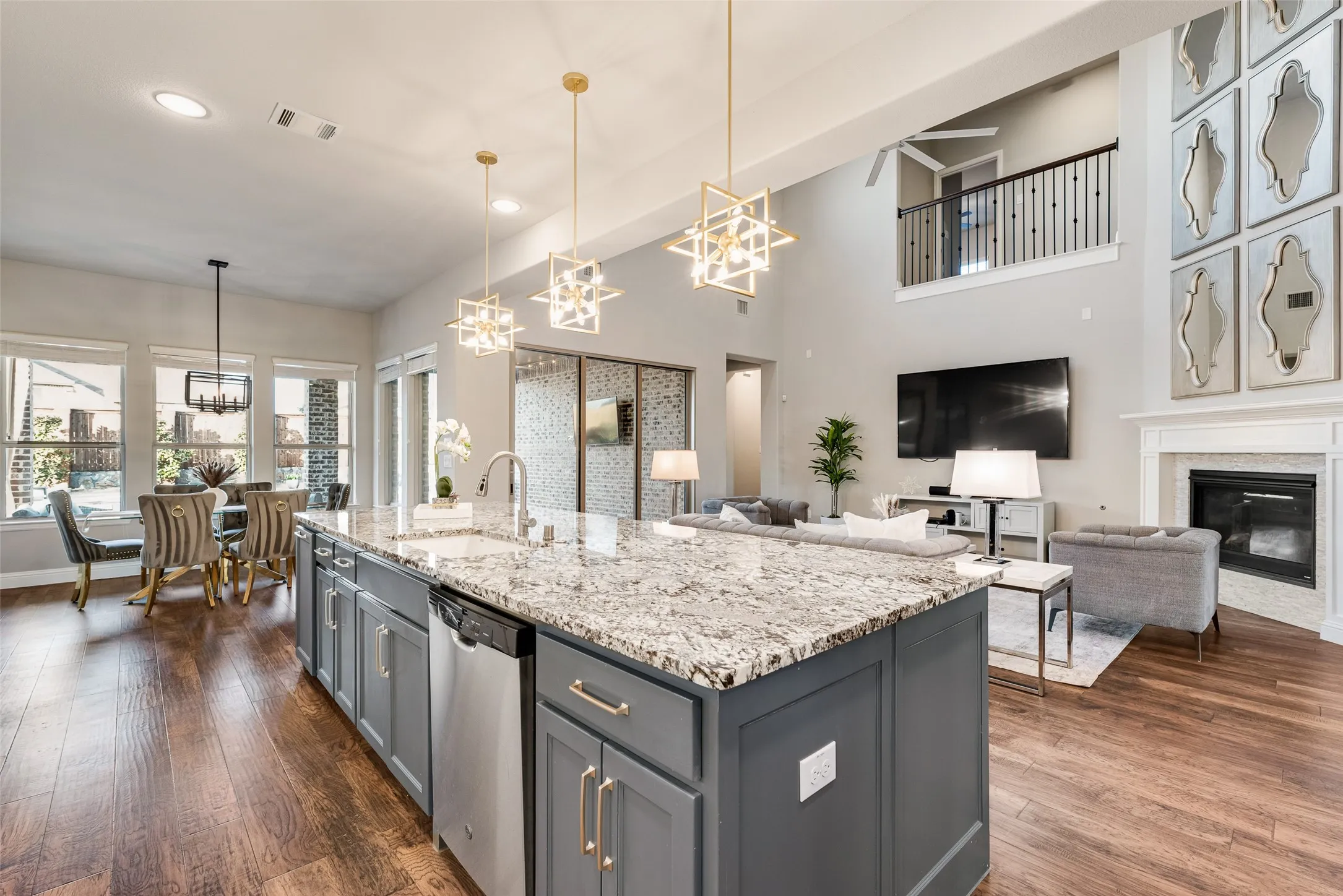 Spacious kitchen island featuring a granite countertop, undermount sink, and integrated dishwasher
