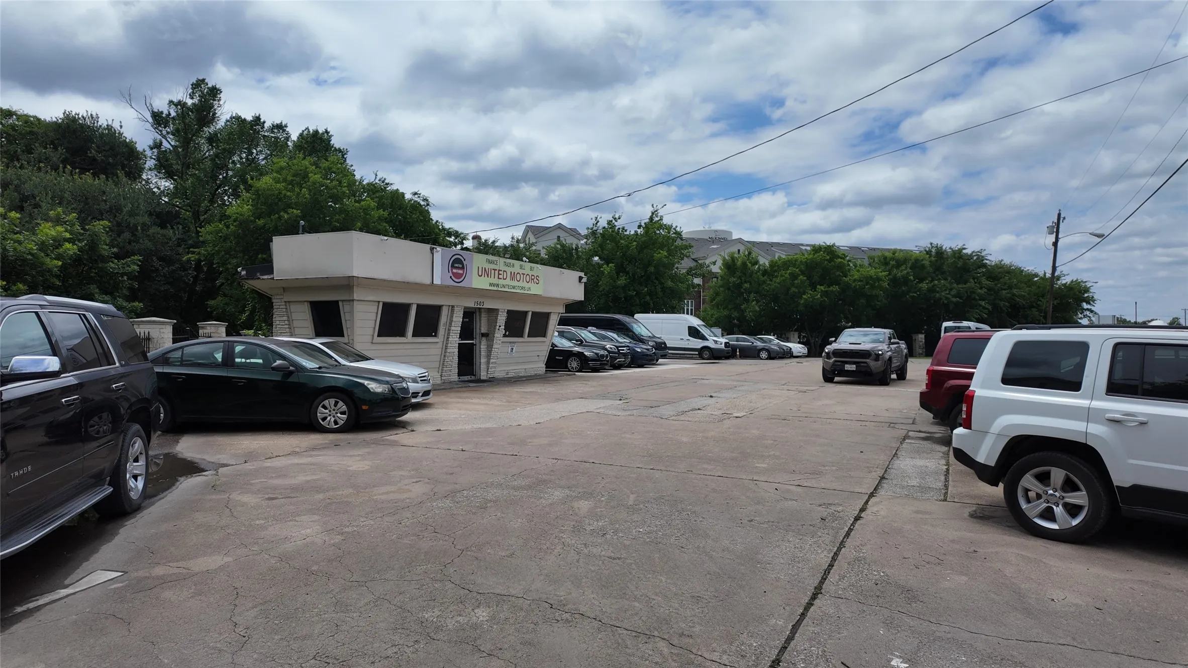 Paved commercial lot featuring a single-story building with a flat roofline, multiple windows, and a prominent sign fascia