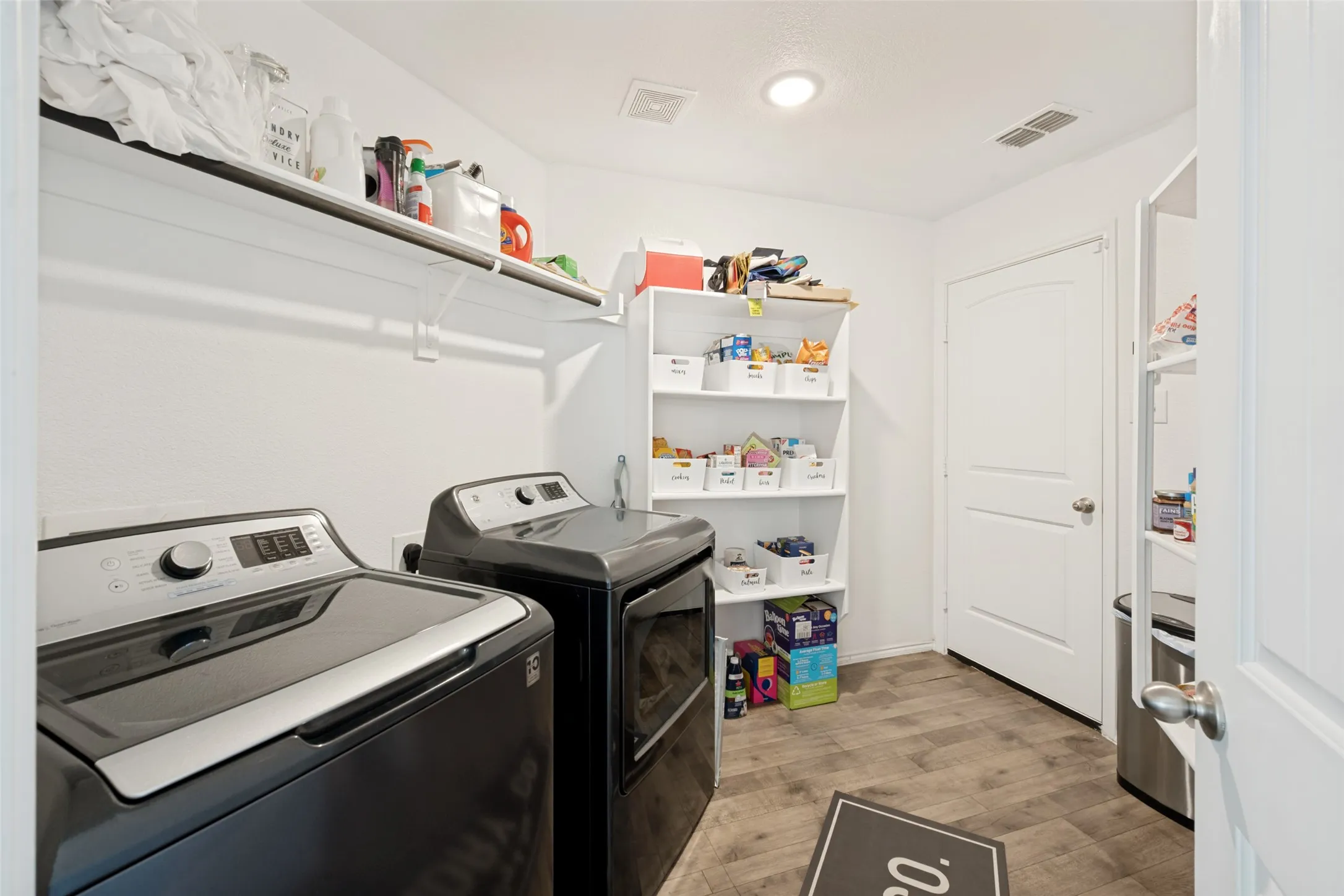 Oversized Laundry Room and shelved Pantry leads out to garage.