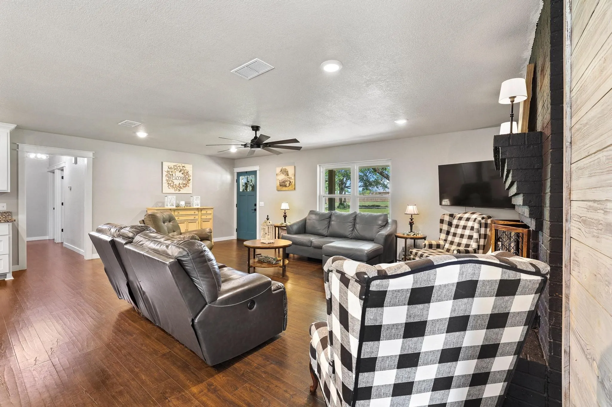 Spacious living area featuring wood-finish flooring, recessed lighting, and a ceiling fan