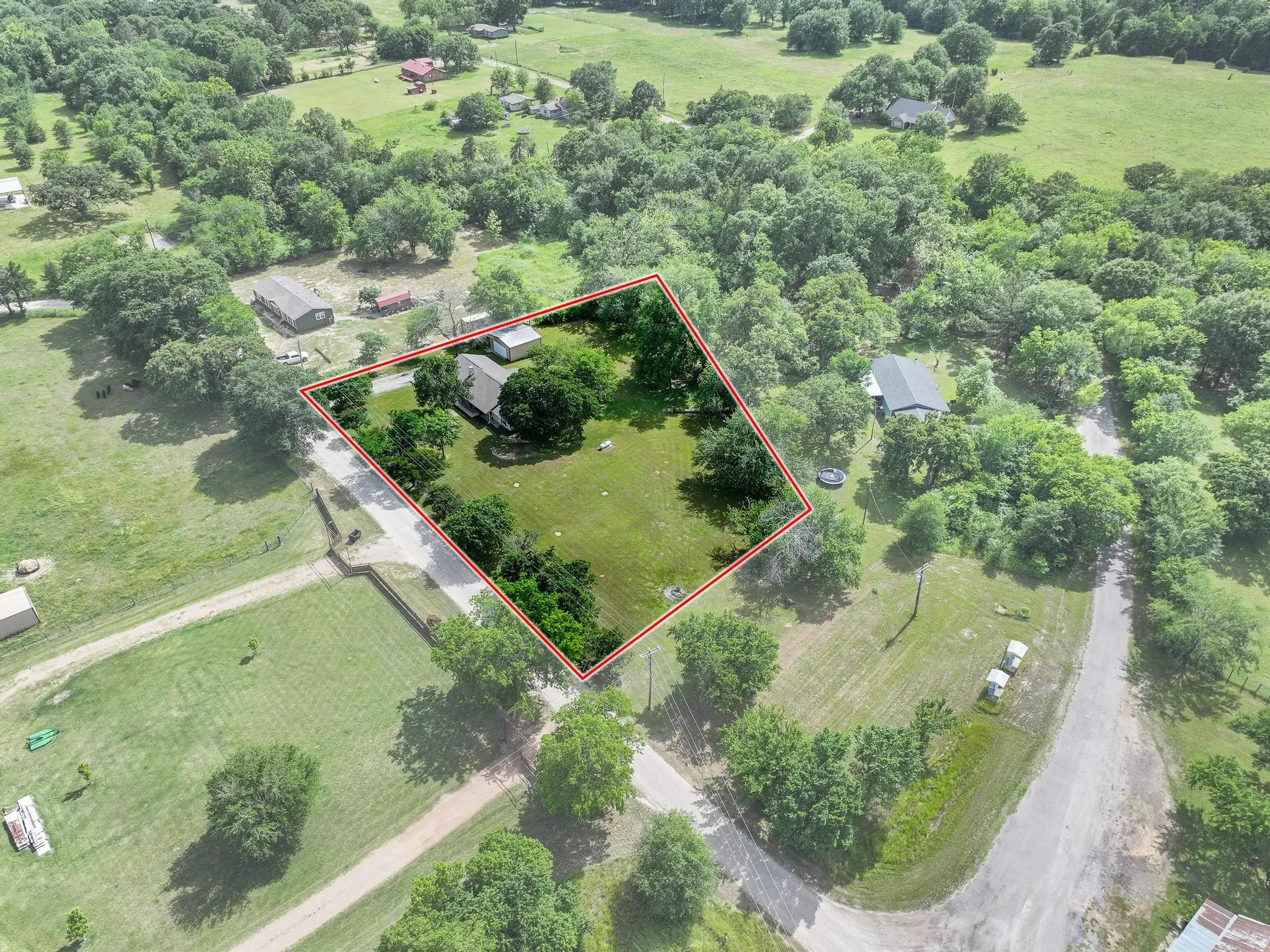 Aerial perspective showcasing a property surrounded by mature trees and expansive green spaces
