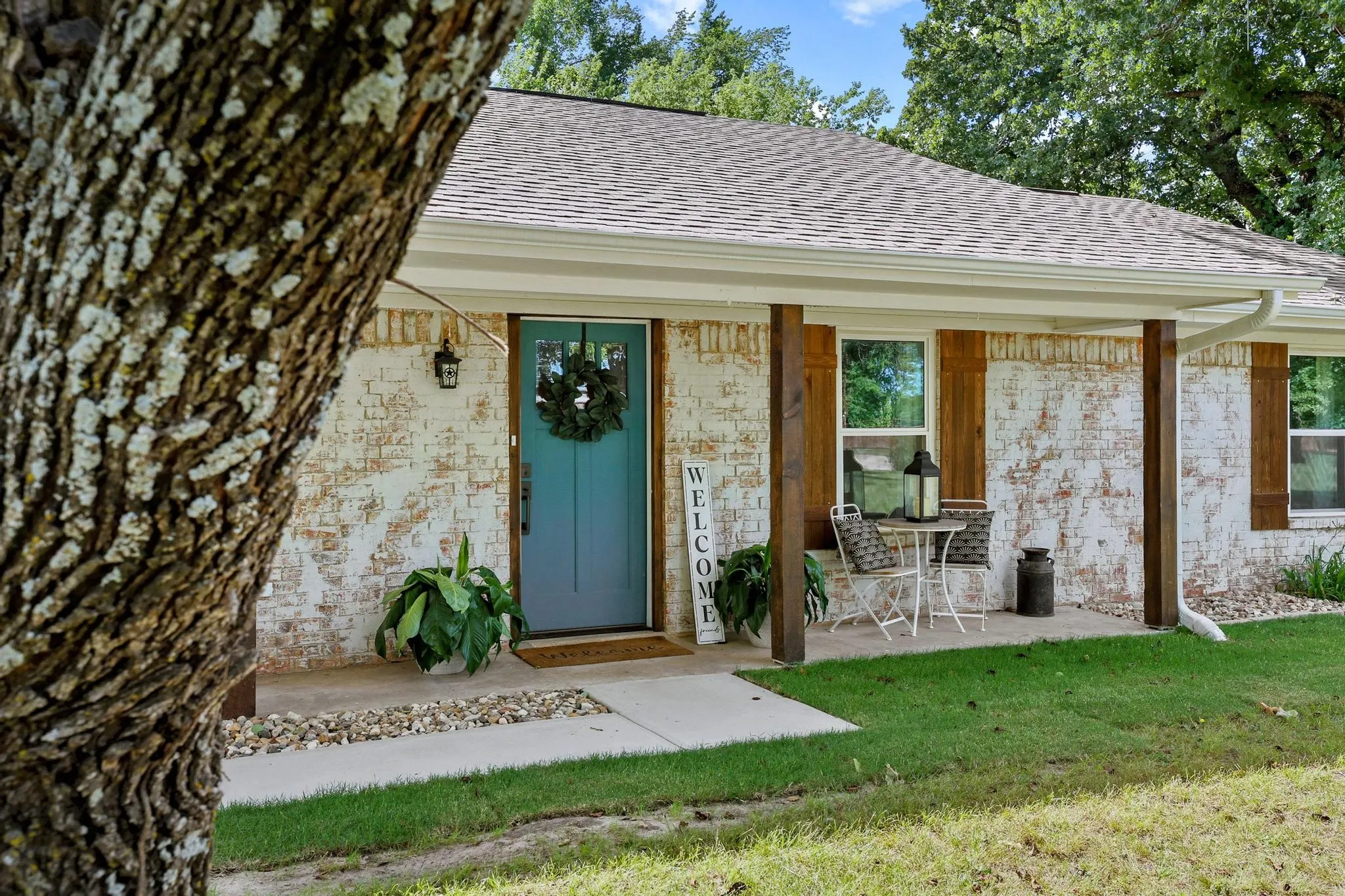 Front exterior featuring white-washed brick, wood support columns, and a covered porch