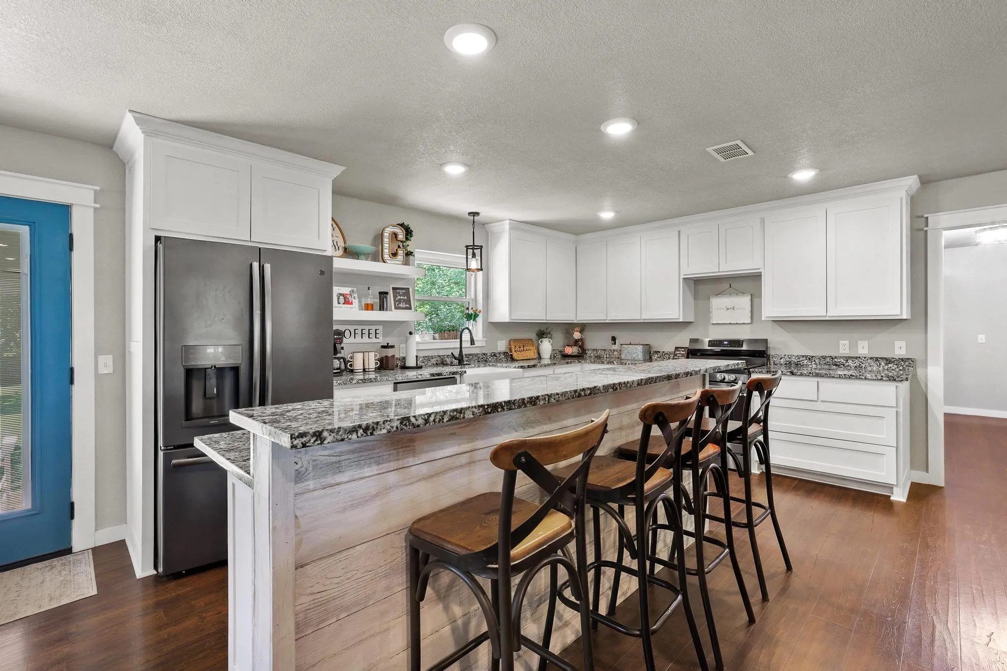 Kitchen featuring white cabinetry, granite countertops, and wood-finish flooring