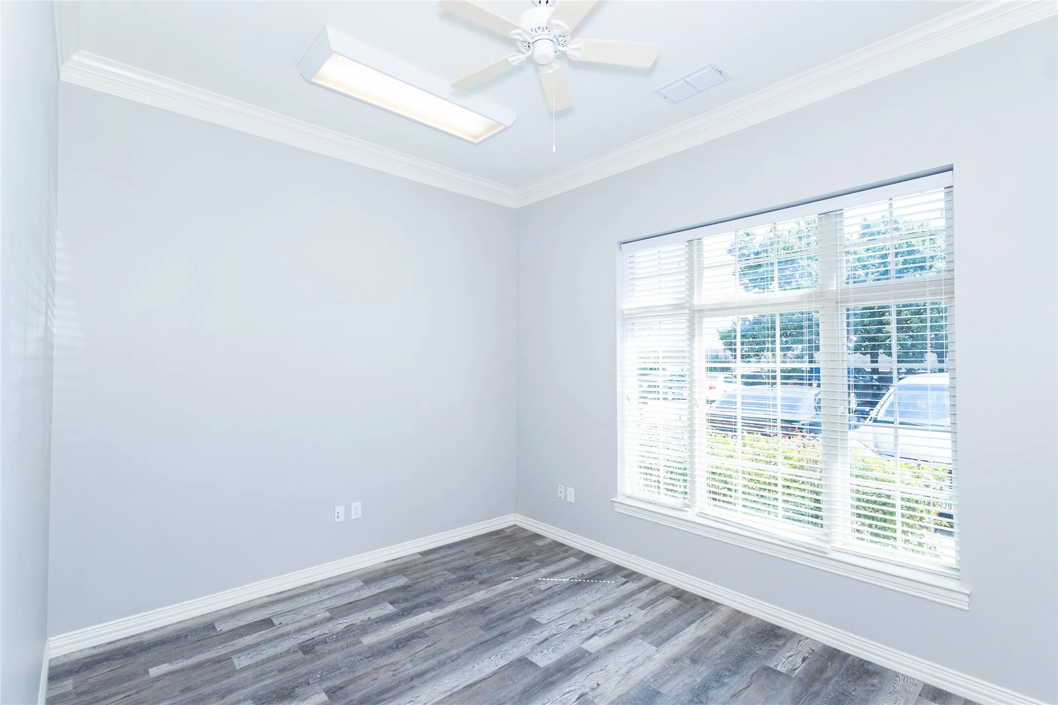 Spare room featuring crown molding and wood finished floors