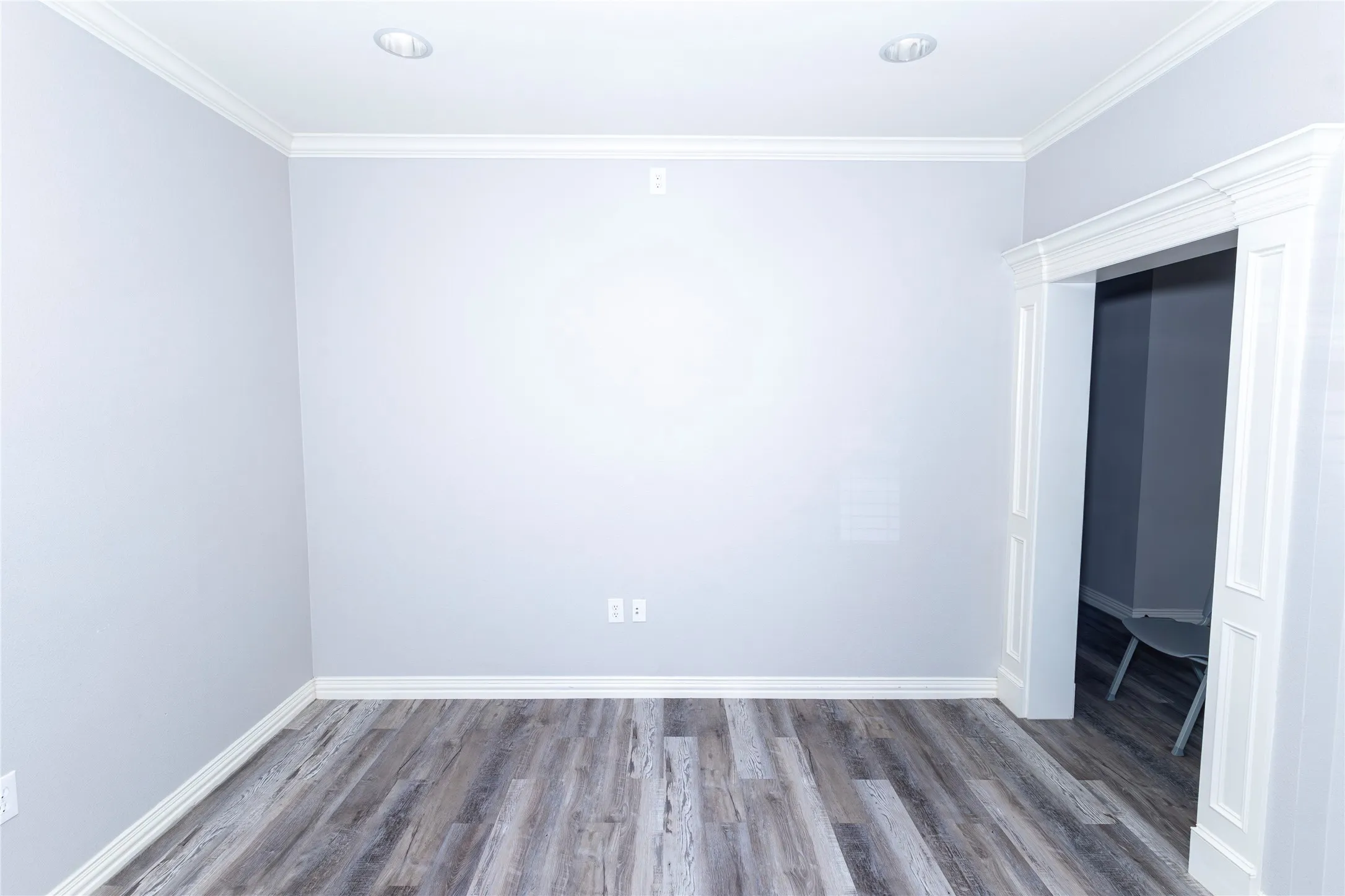 Spare room featuring wood finished floors and crown molding
