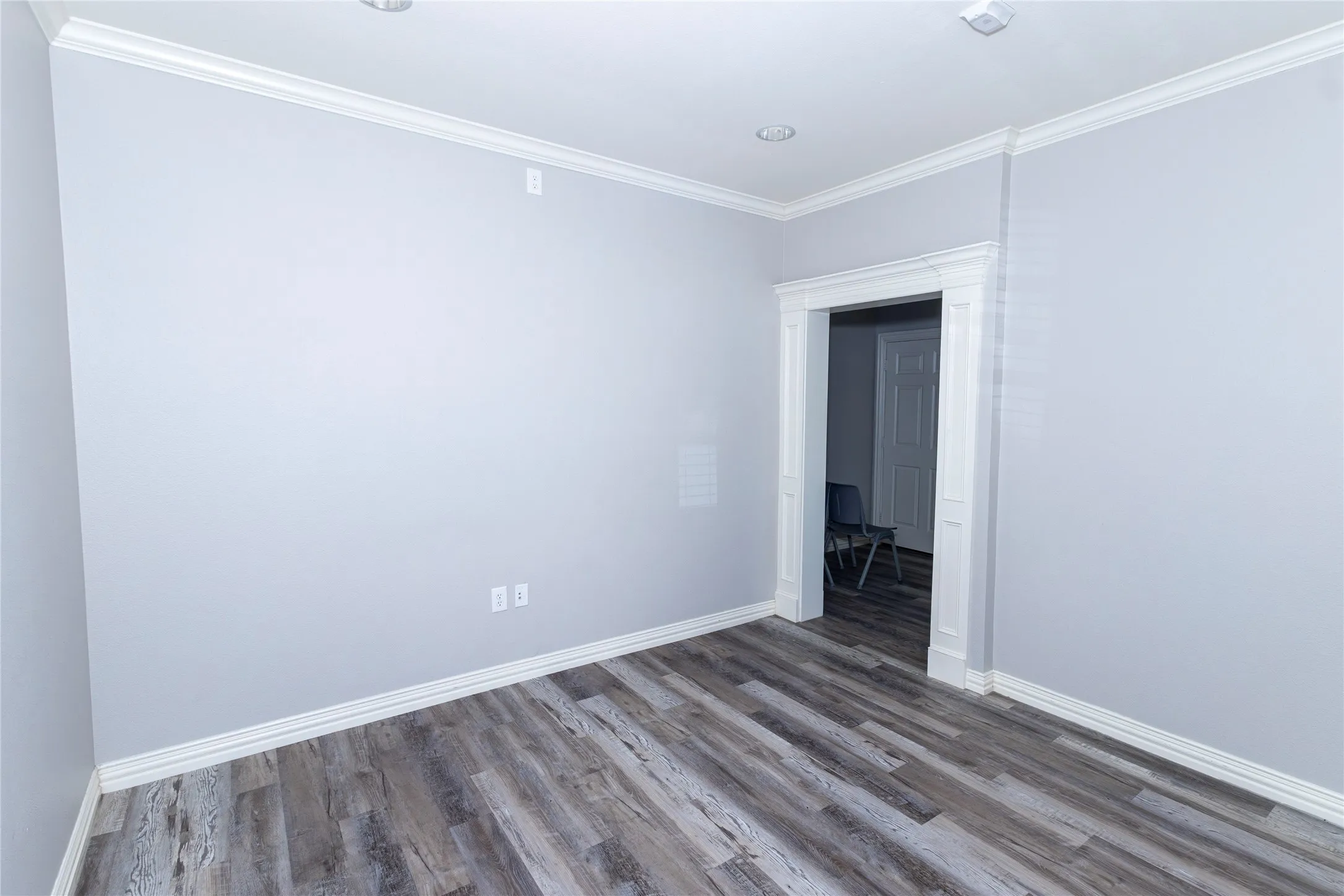 Unfurnished room with ornamental molding and wood finished floors