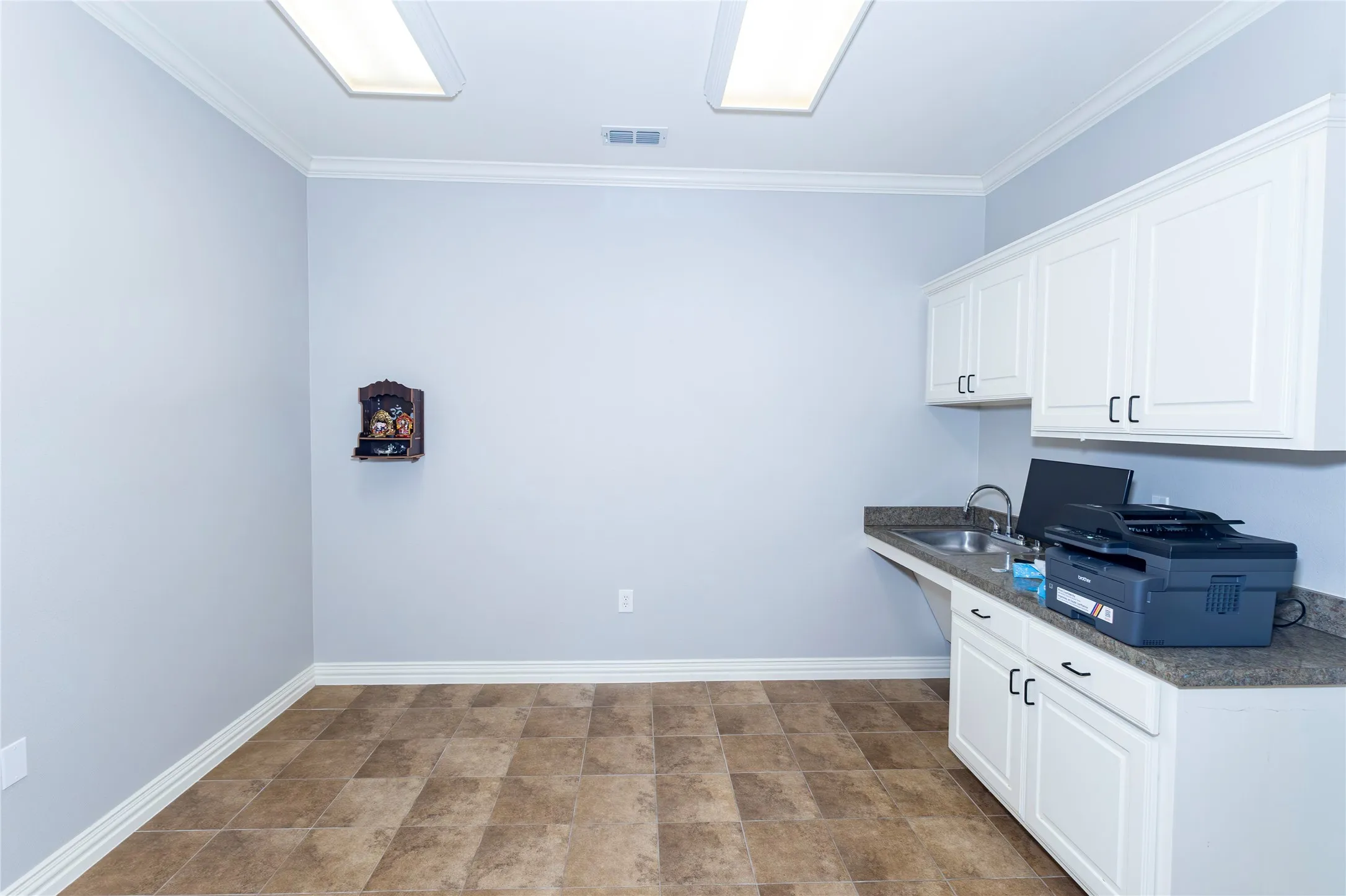 Kitchen featuring white cabinets and crown molding