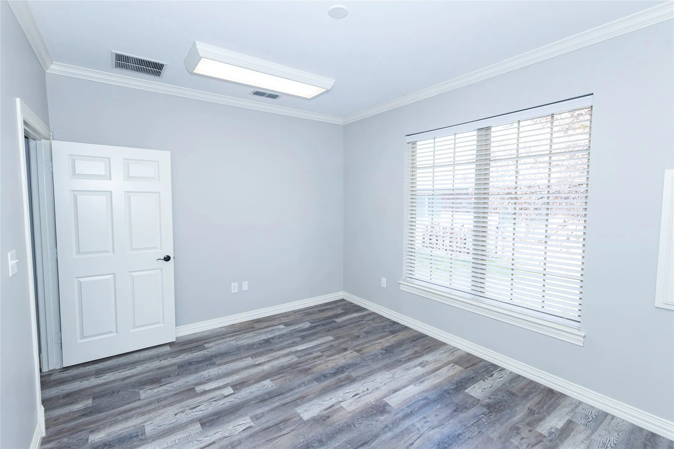 Empty room featuring crown molding and wood finished floors