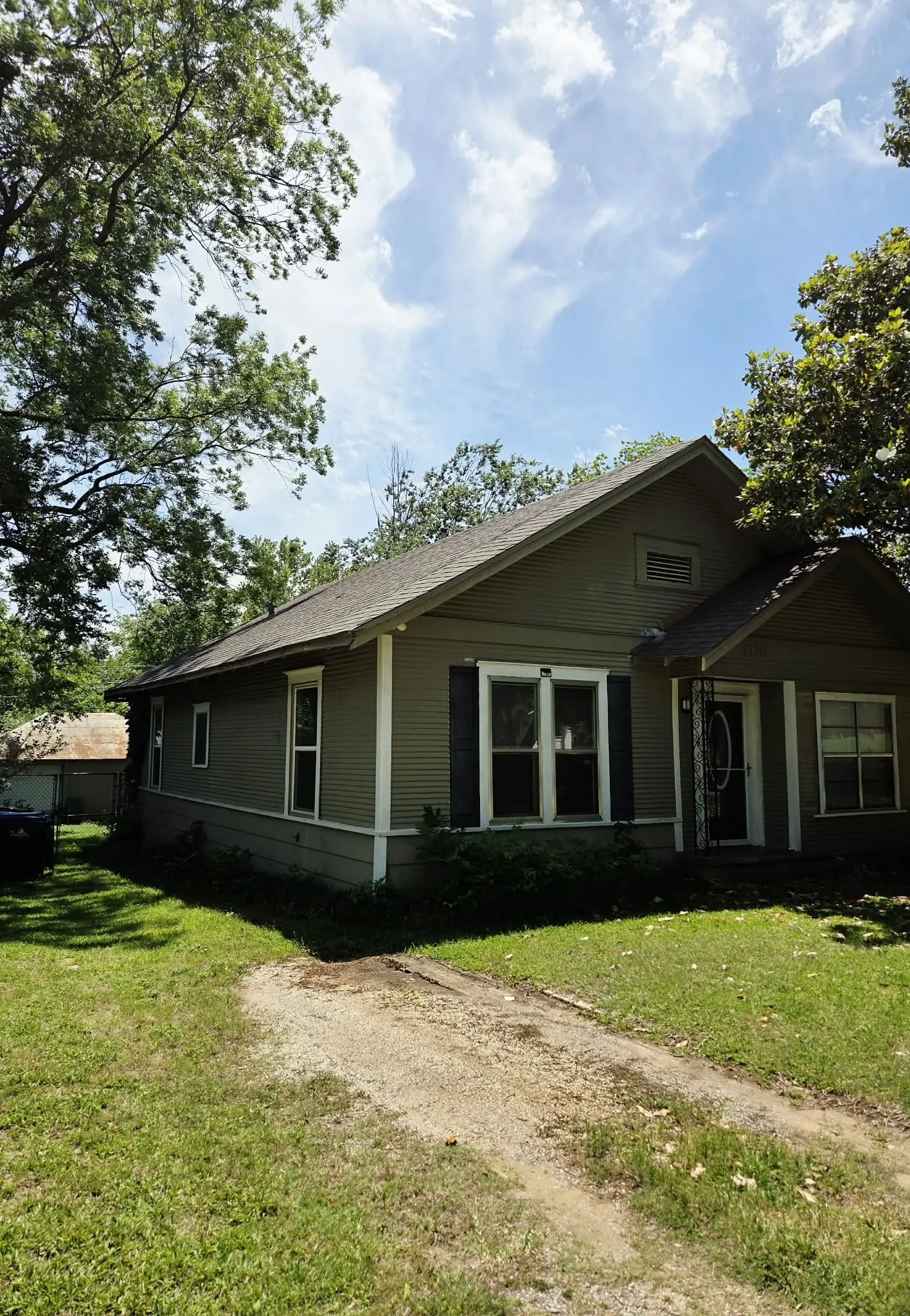 Single-story residence featuring a gray exterior siding, white trim, and dark shutters