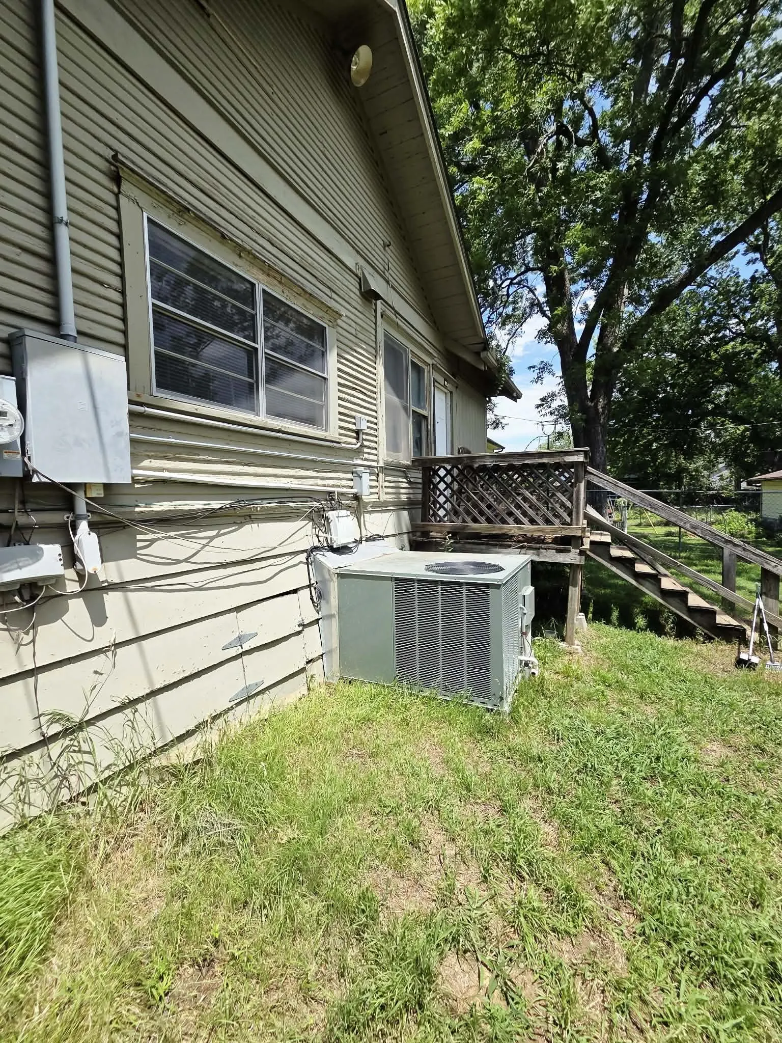 Exterior siding with multiple windows and an outdoor air conditioning unit