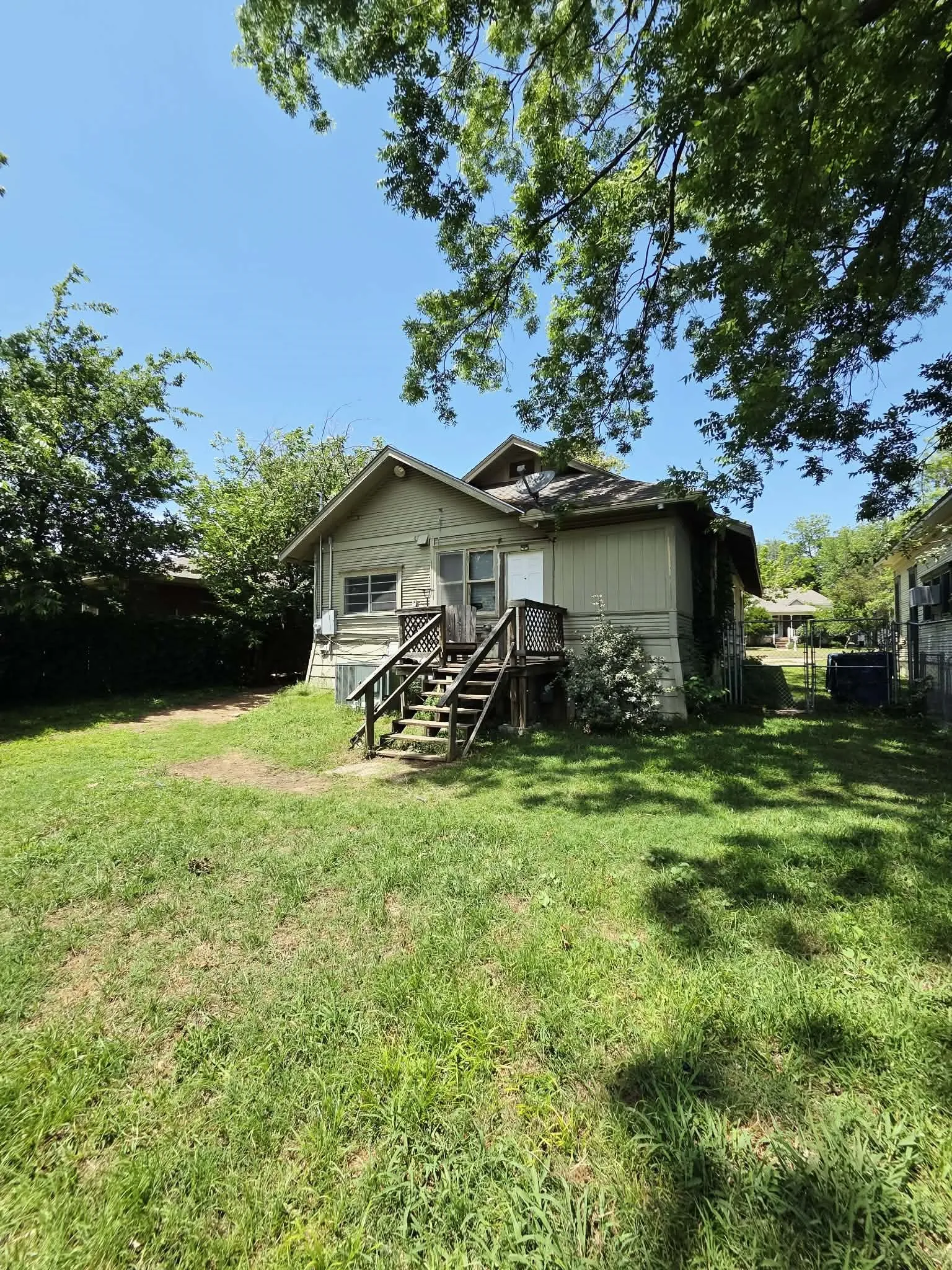 Rear exterior featuring wood siding and a multi-level wooden deck with stairs