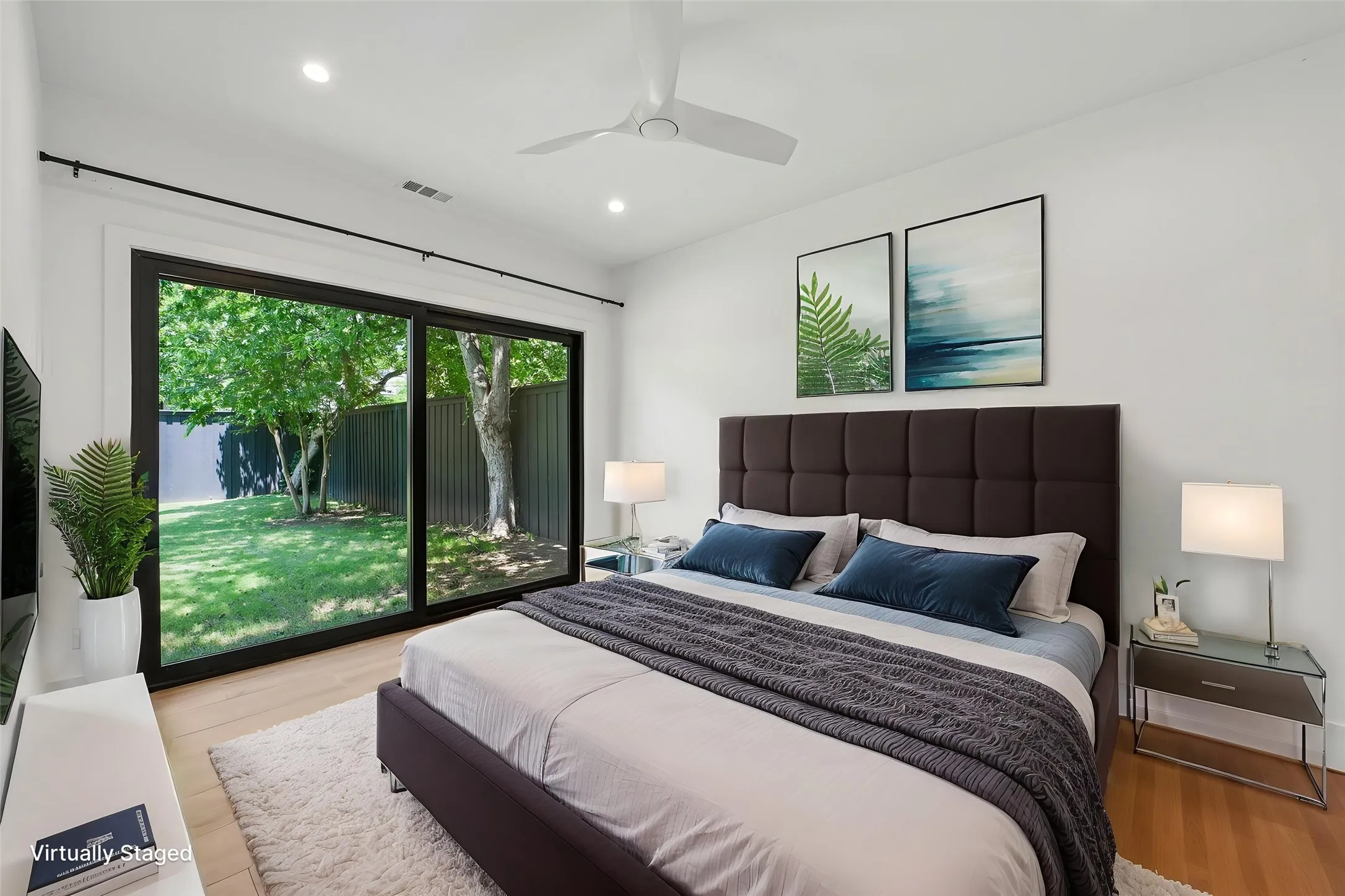 Bedroom with oversized sliding glass doors opening to a private backyard