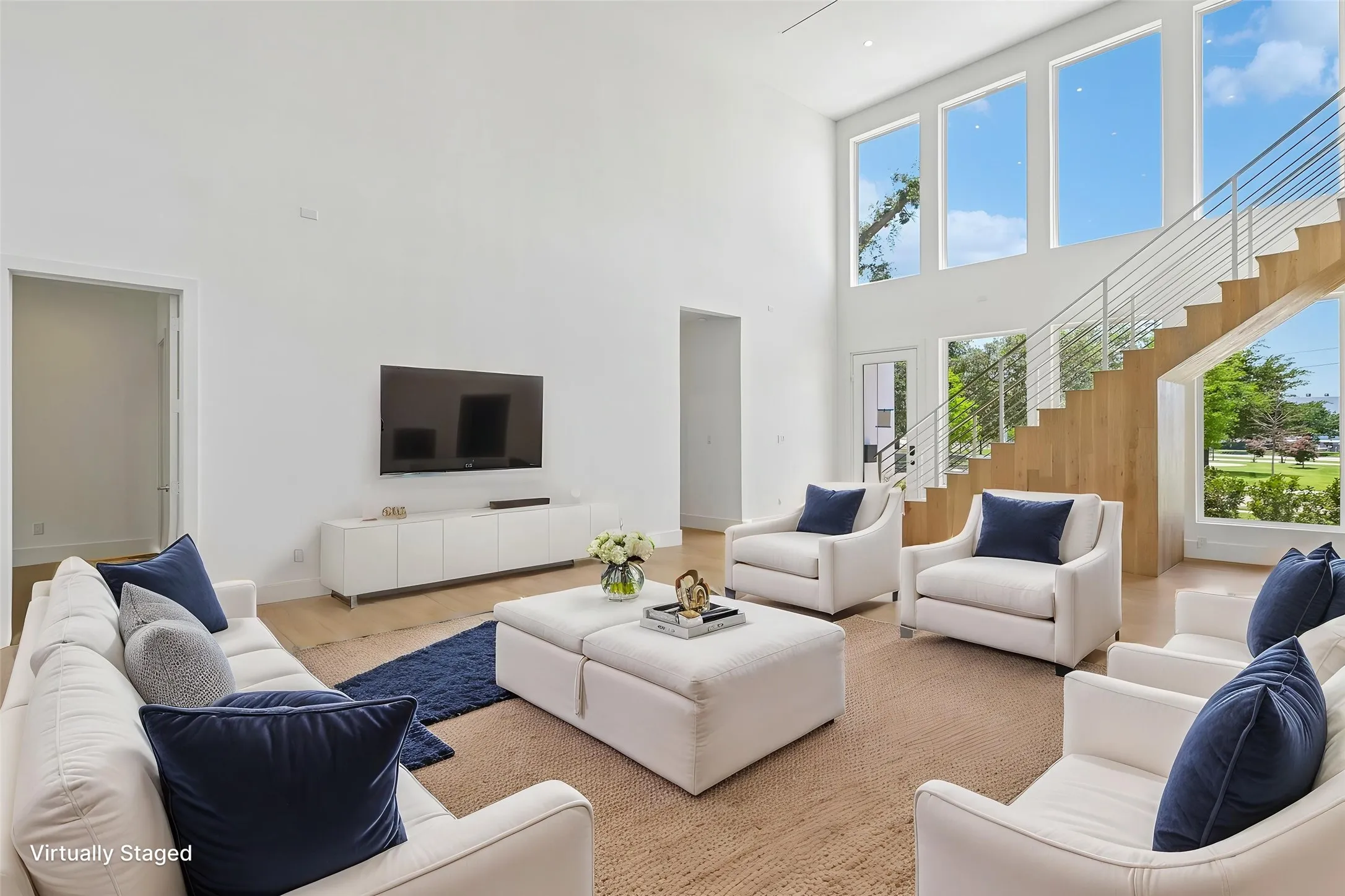Two-story living area featuring tall ceilings and abundant natural light from multiple large windows