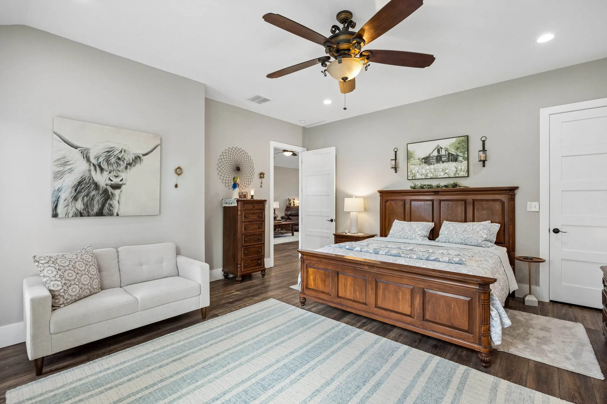 Spacious room featuring wood-finish flooring and a ceiling fan with integrated lighting