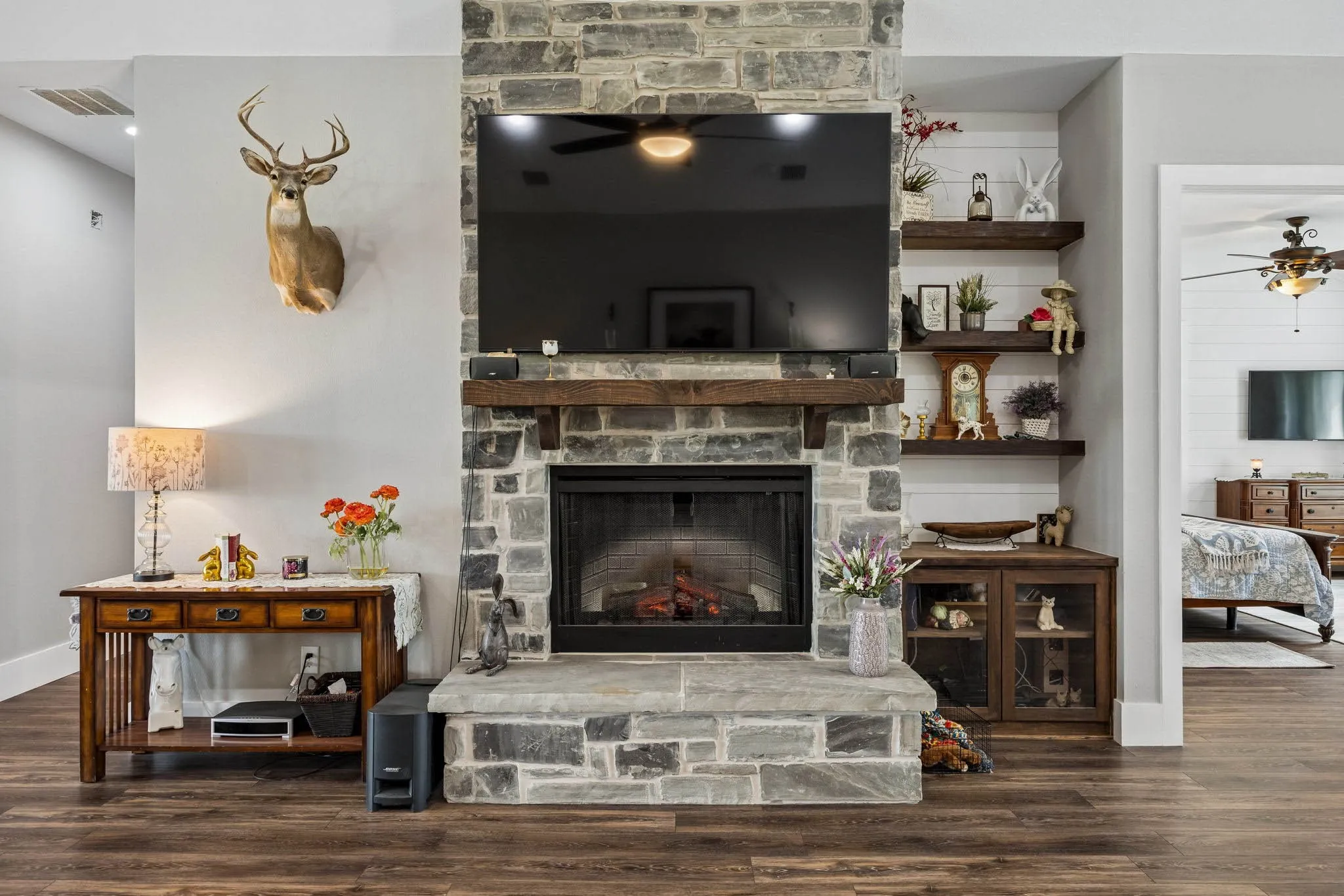 Stone-clad fireplace with a substantial hearth and distressed wood-finish mantel