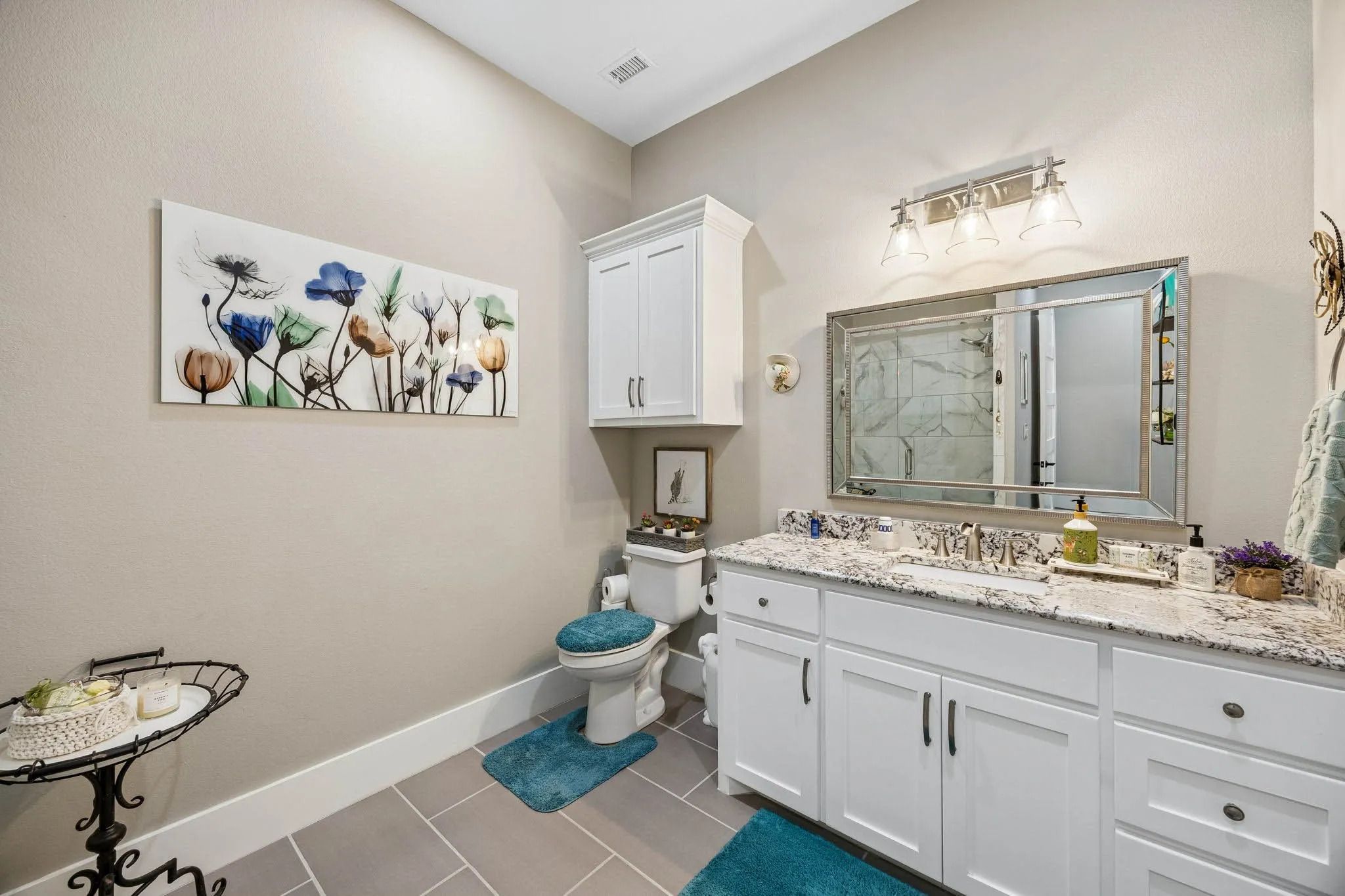 Bathroom featuring a white vanity with a granite countertop, undermount sink, and brushed nickel faucet