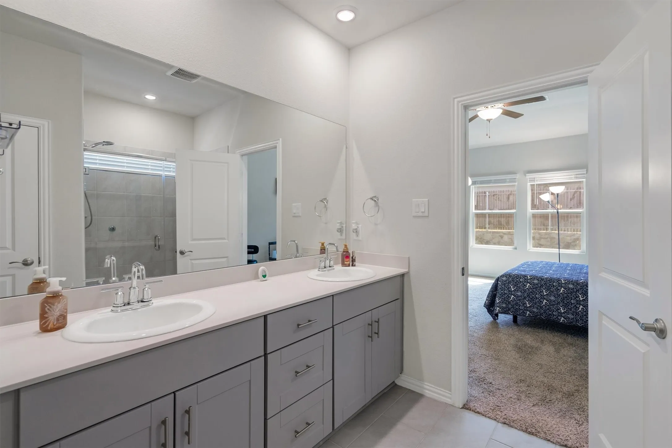 Dual vanity with light gray cabinetry and white countertops