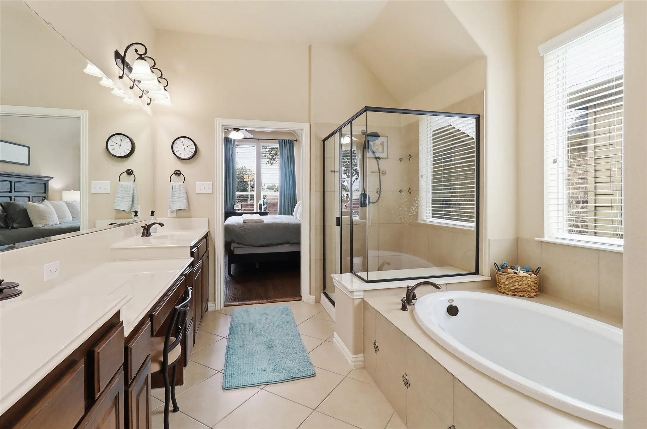 Spacious bathroom featuring a built-in soaking tub, a glass-enclosed shower, and a double vanity with an integrated mirror