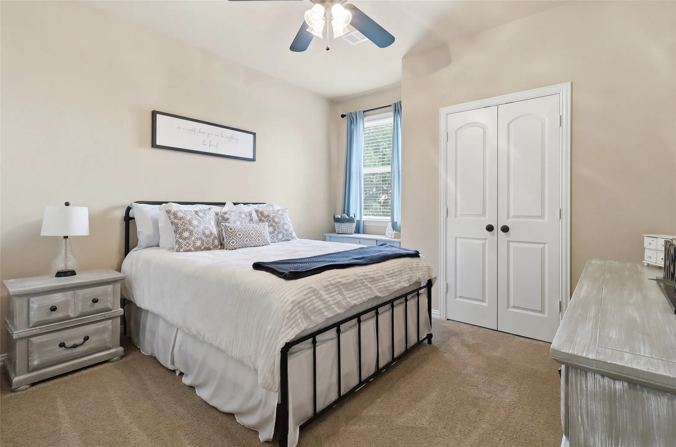 Carpeted bedroom with neutral wall tones and a window featuring natural light