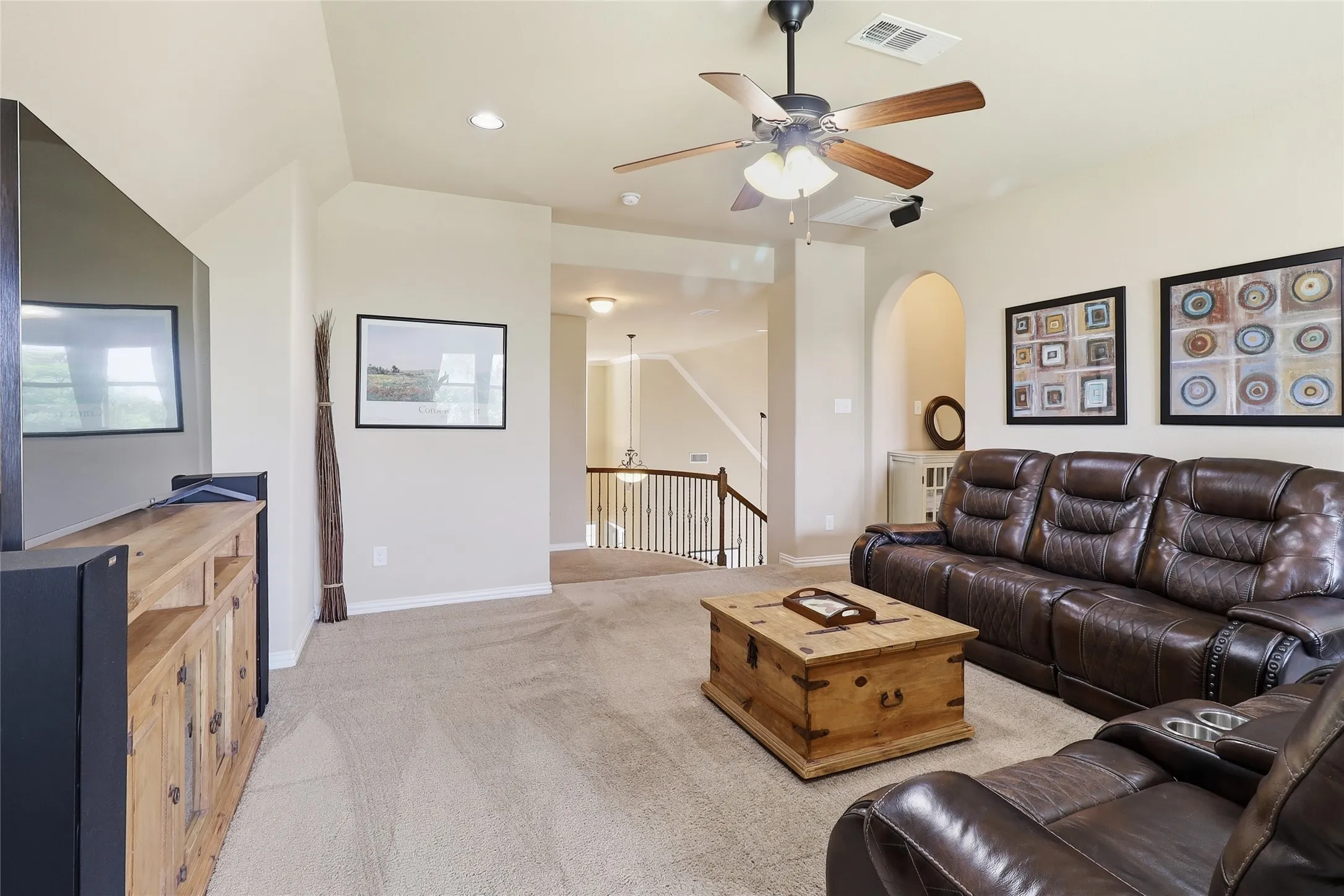UpstairsCarpeted living area featuring a ceiling fan with integrated lighting, recessed lighting, and an arched doorway
