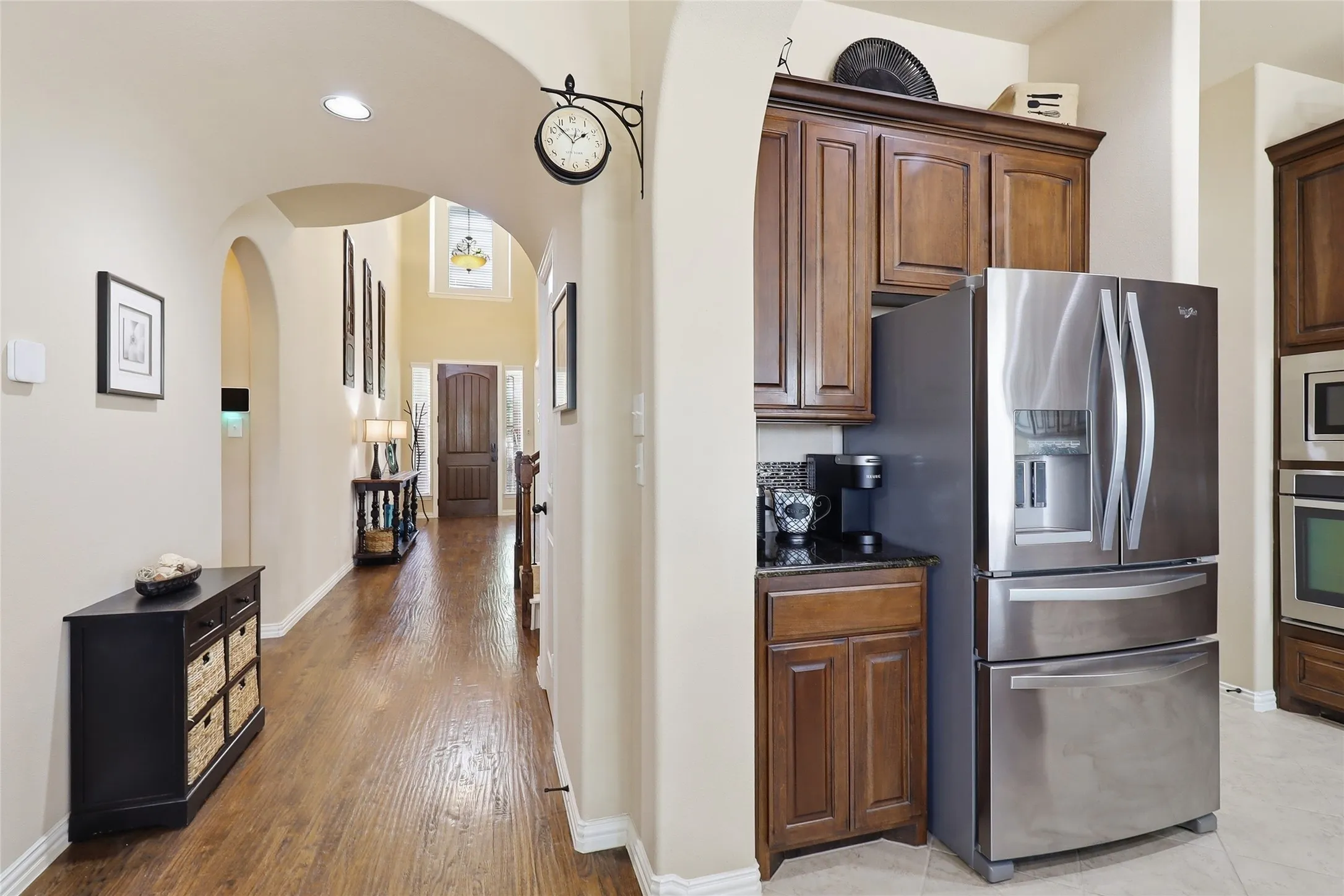 Kitchen area featuring stainless steel French door refrigerator, dark wood-finish cabinetry, and dark countertop