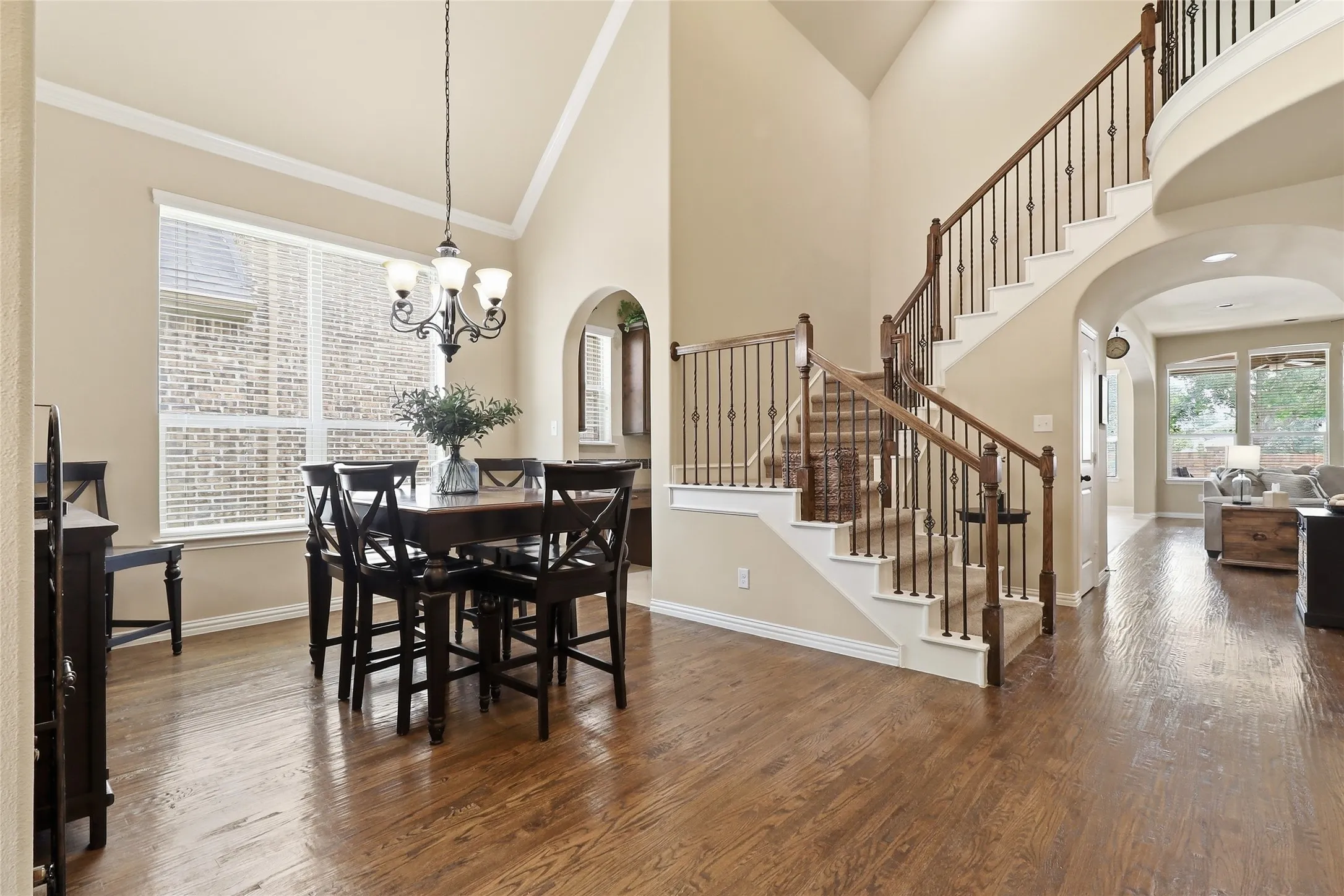 Grand entry with hardwood flooring and a curved staircase featuring wrought iron balusters