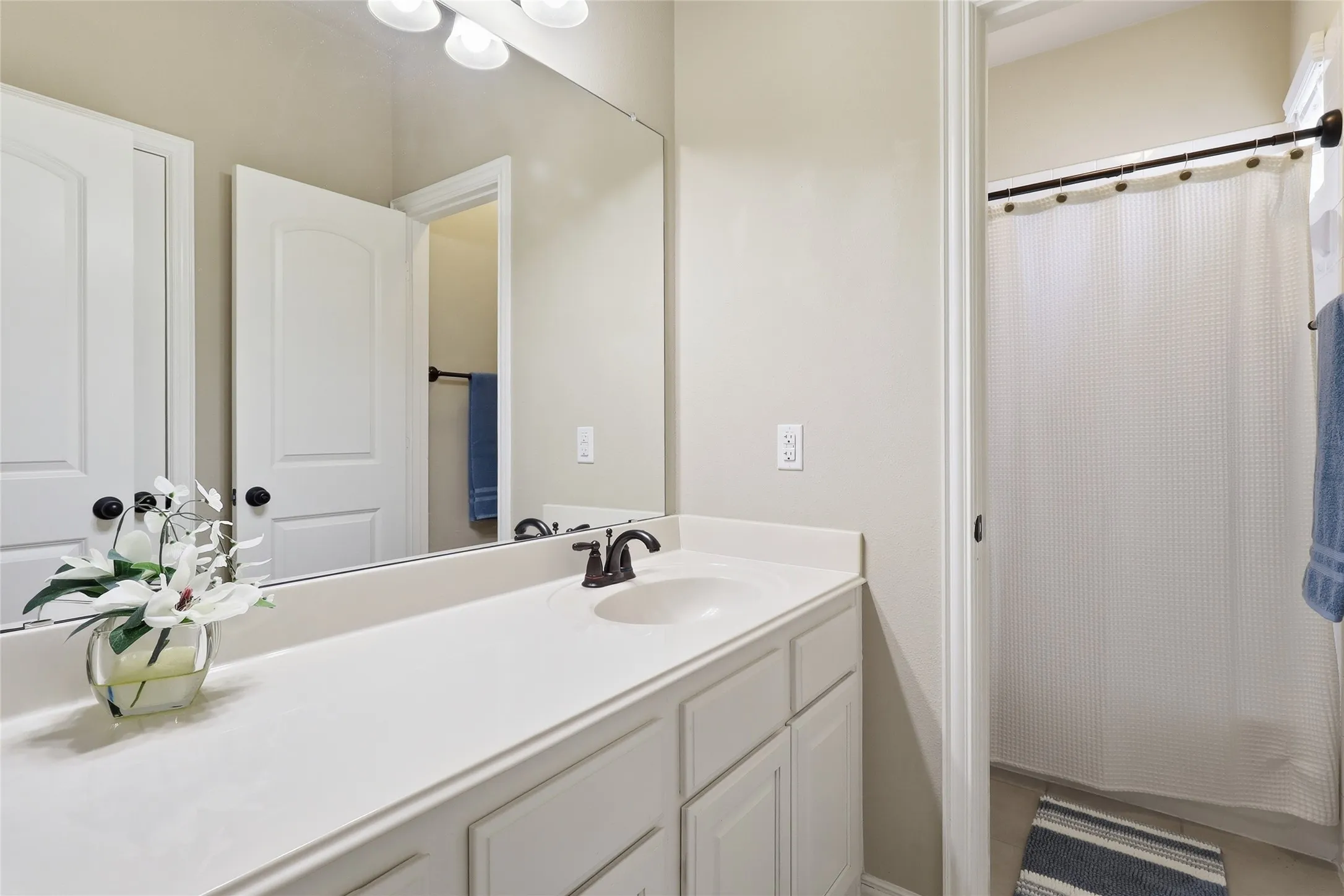 Spacious vanity with an integrated sink, broad mirror, and built-in cabinetry