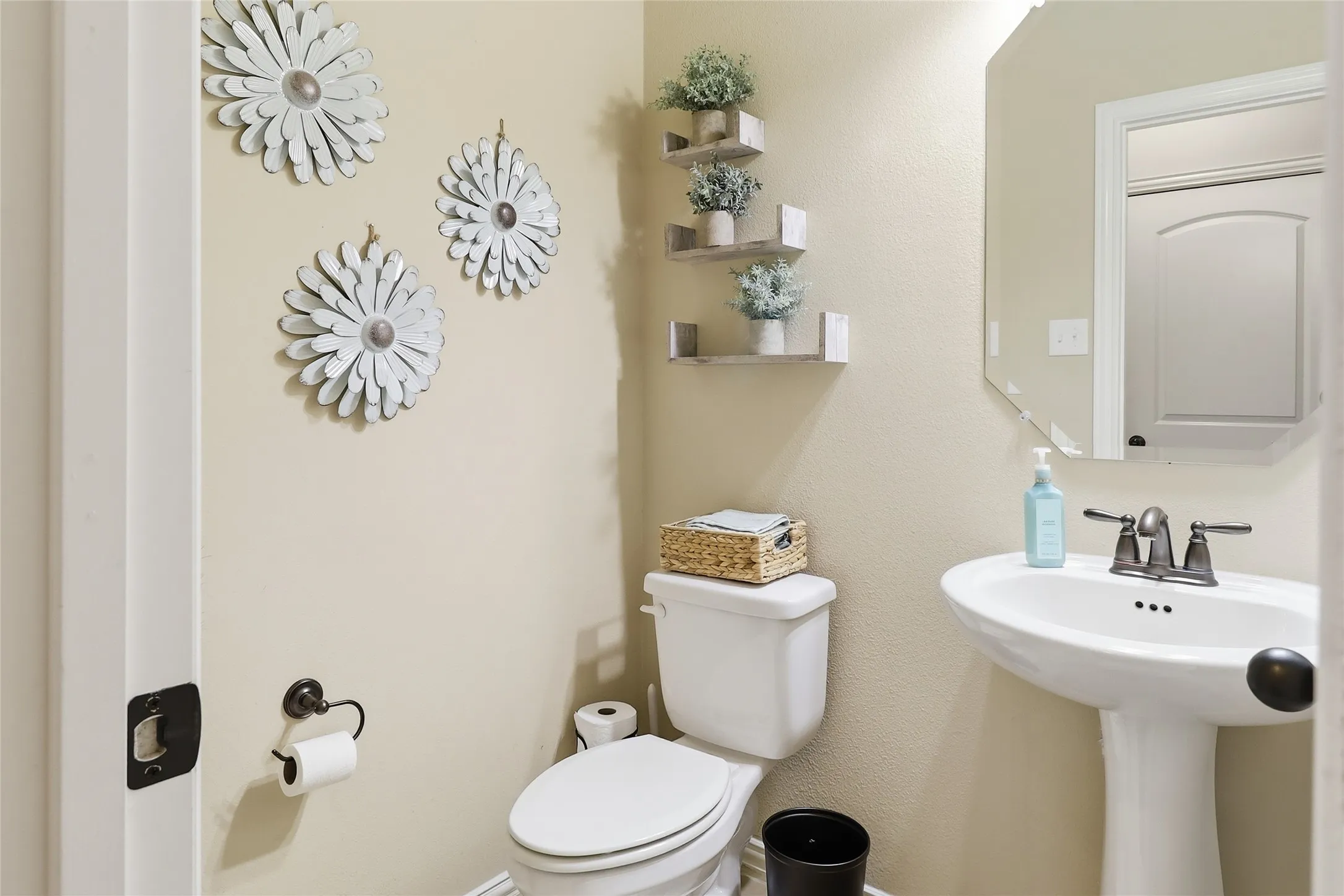 Pedestal sink with a two-handle faucet and an octagonal wall mirror