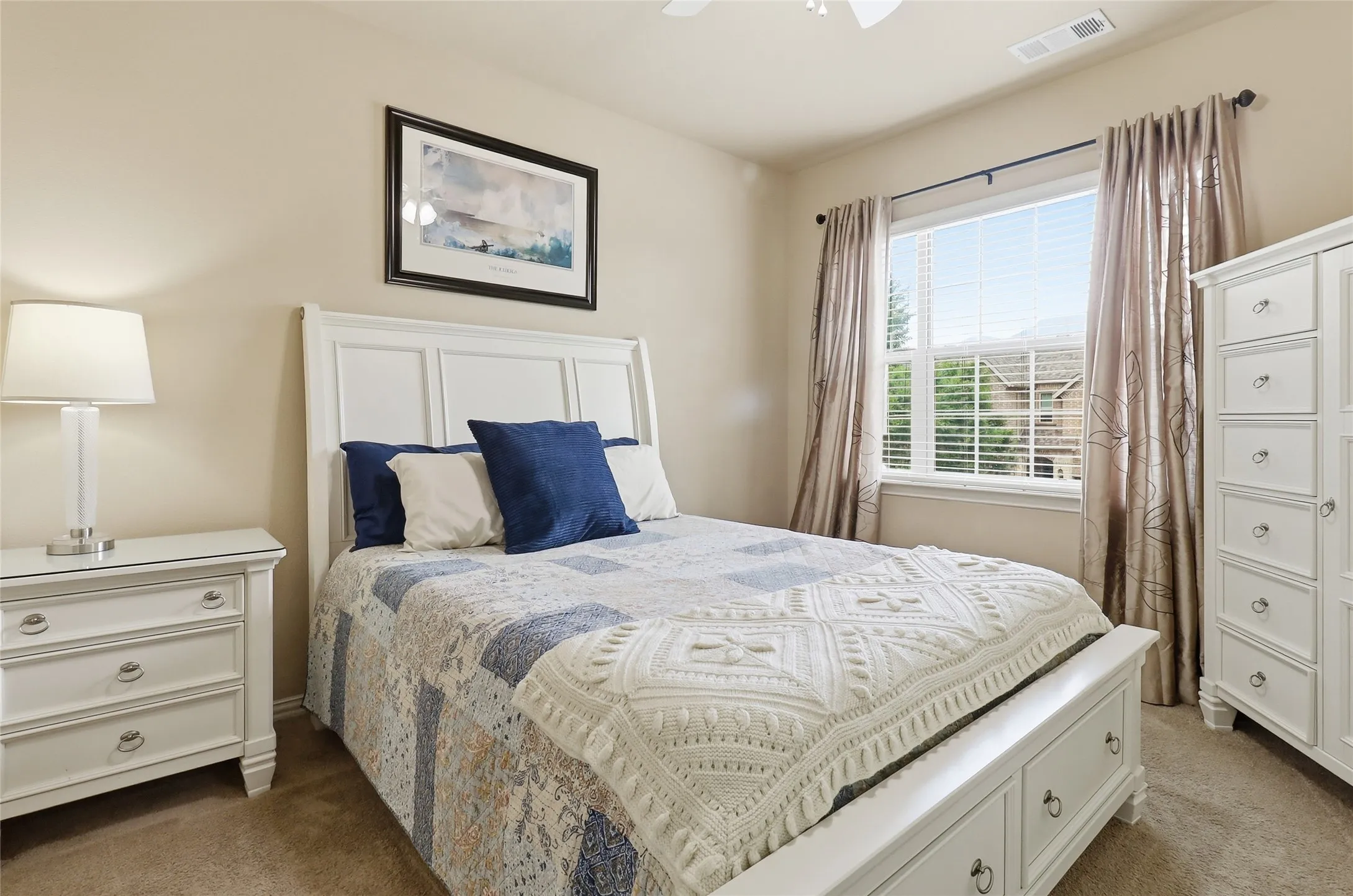 Bedroom featuring a panel headboard, carpeted flooring, a window with blinds, and neutral wall tones