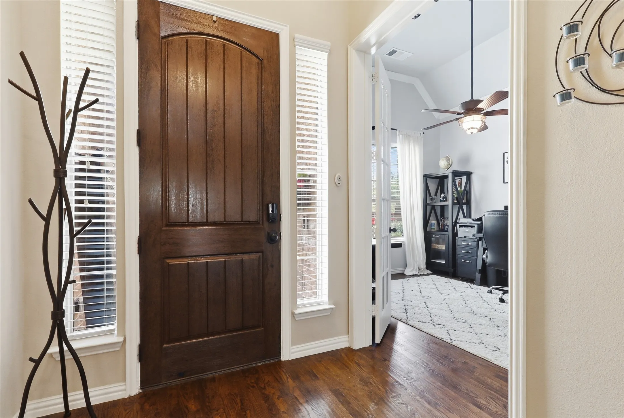 Rich wood-finish flooring complements the substantial wood entry door with side light windows