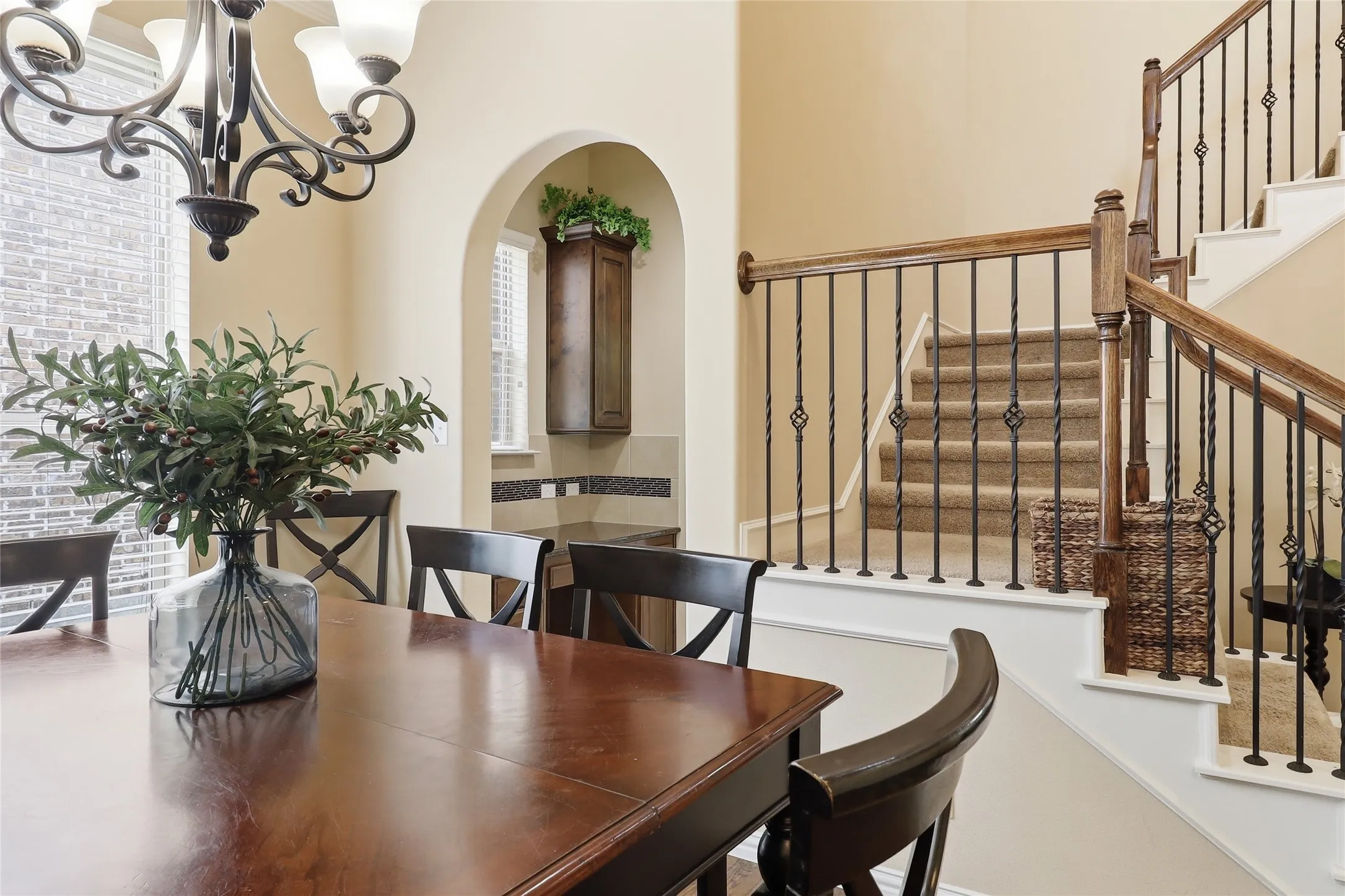 Crafted staircase featuring wood handrails and wrought iron balusters