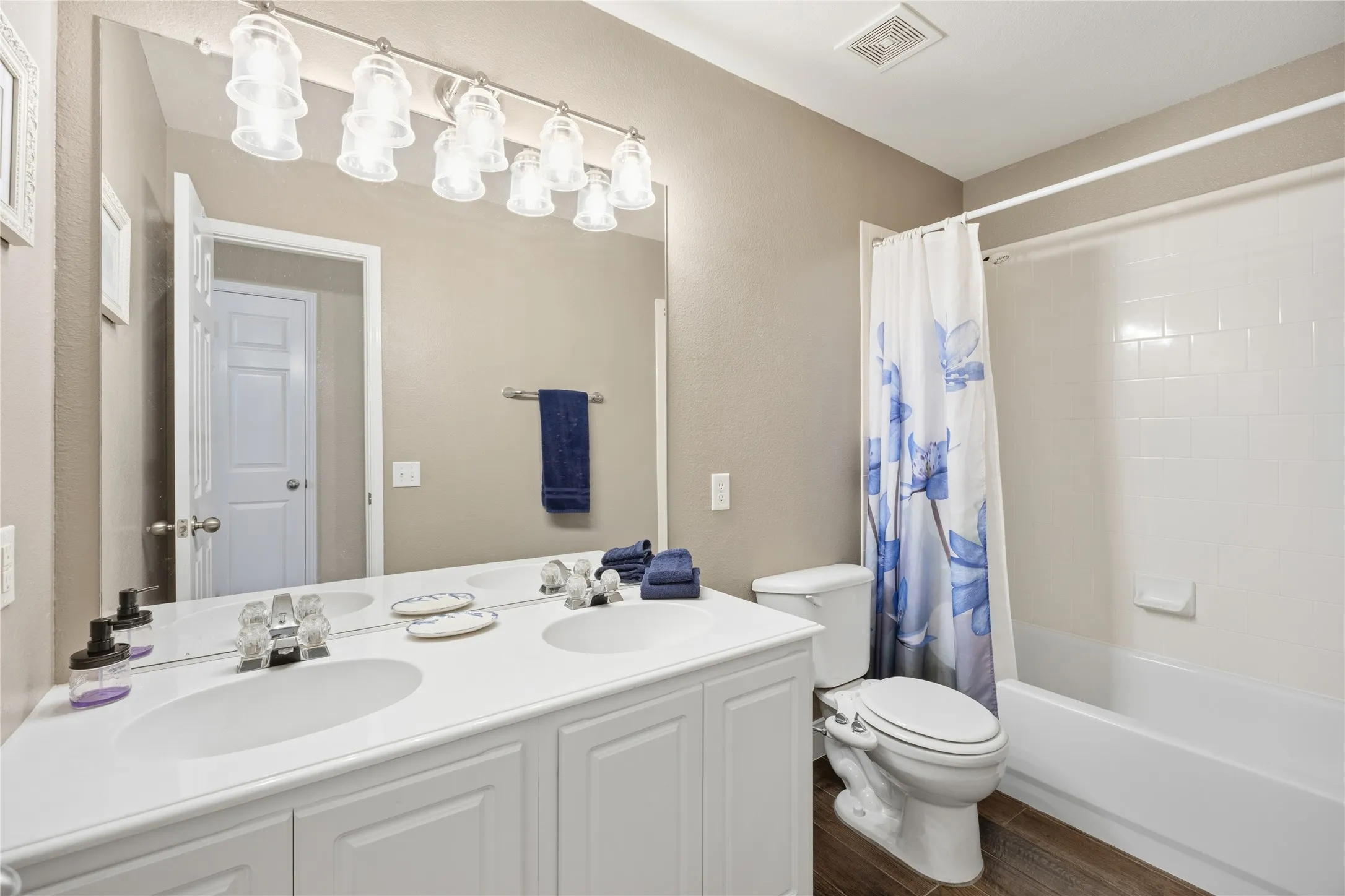 Dual vanity with integrated sinks, brushed nickel fixtures, and a multi-bulb light bar