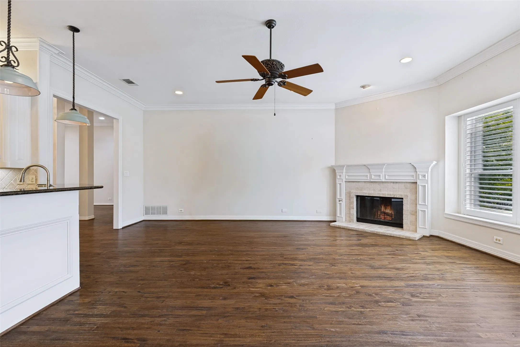 View of the lovely mantled corner fireplace with gas logs.Open floorplan to the causual dining and kitchen.