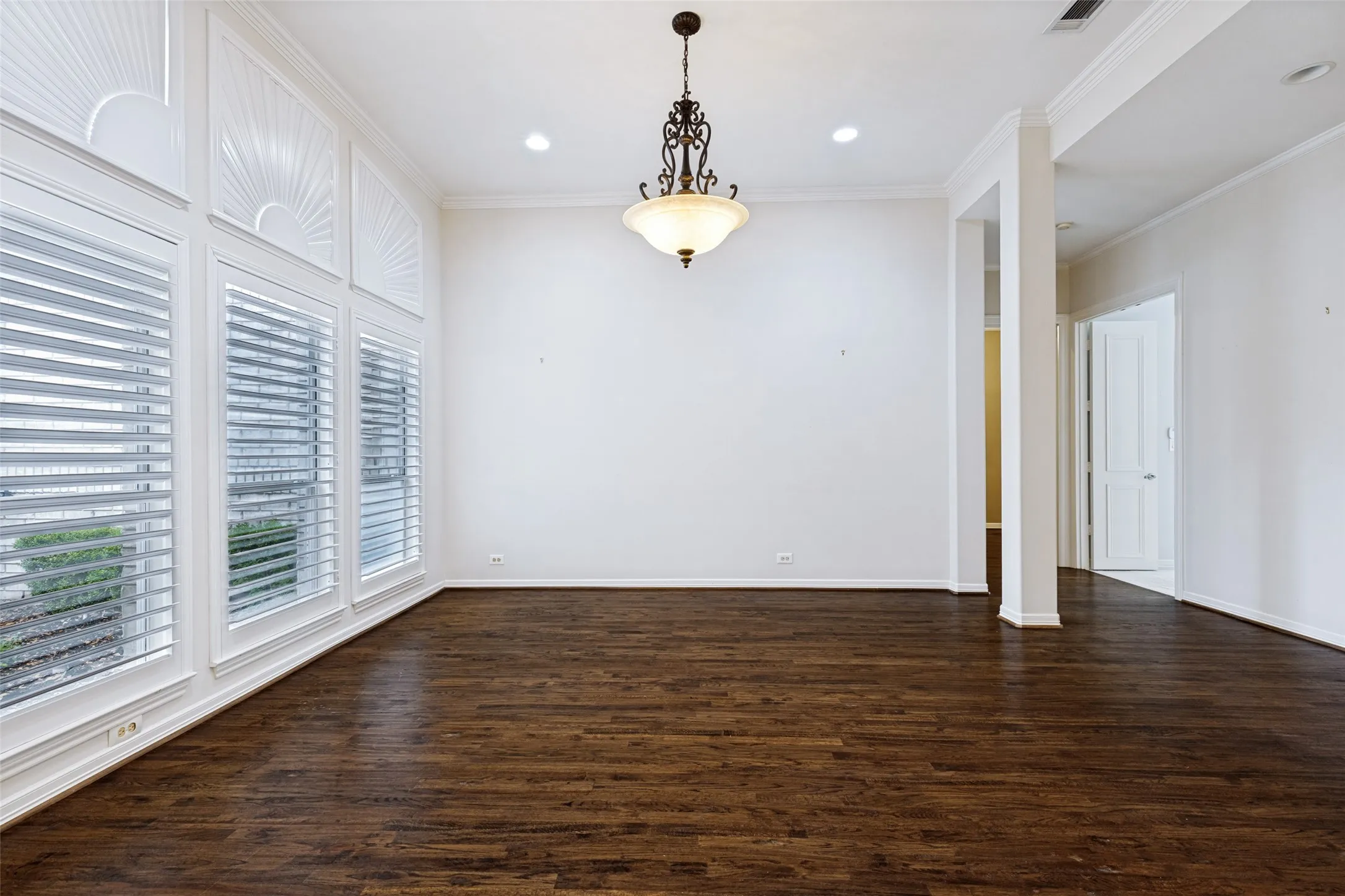 Formal Living is off the foyer, with hardwoods, columns and front window views.